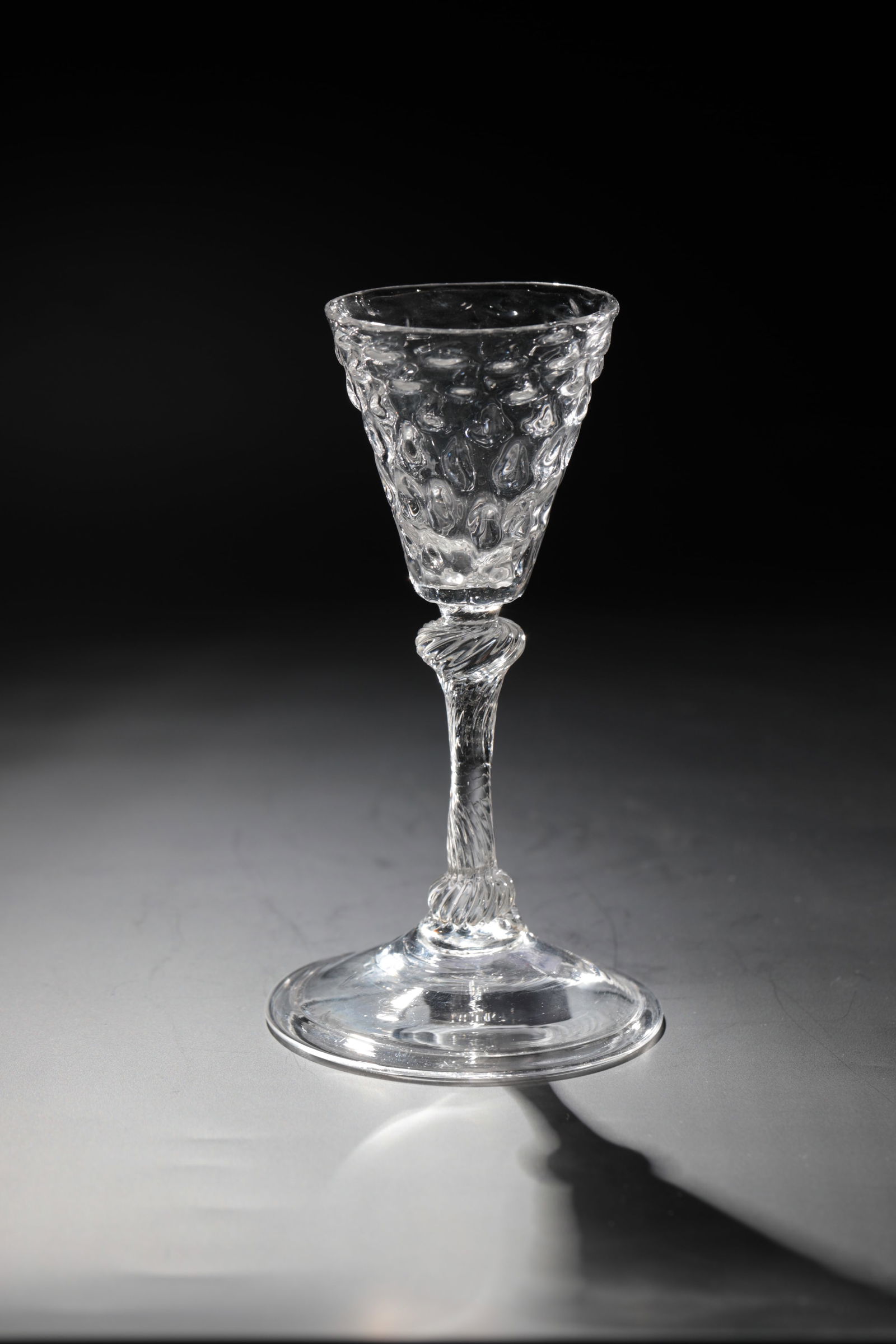 Goblet: Pointed chalice Liège, 18th century Colourless glass with tear-off. Slightly rising disc base with folded edge downwards. Spirally twisted shaft with two nodes. Kuppa with optical wart decoration. H.
