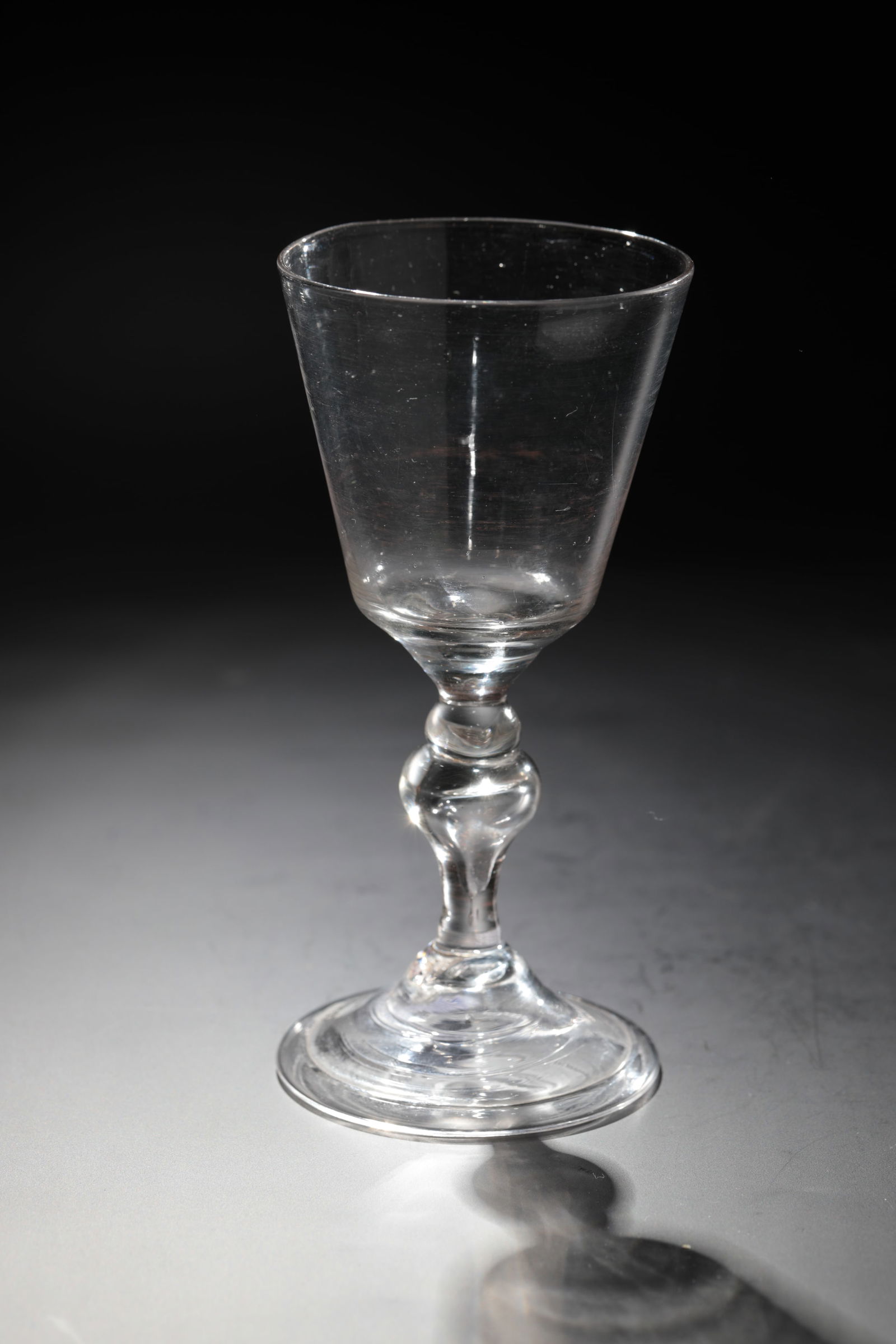 Goblet glass: Goblet glass France, 18th century Colourless glass with tear-off. Disc base with the edge folded downwards. Hollow baluster shaft. Conically widened cuppa. h. 14 cm Cf. Lit.: Form Colour Function, Gla