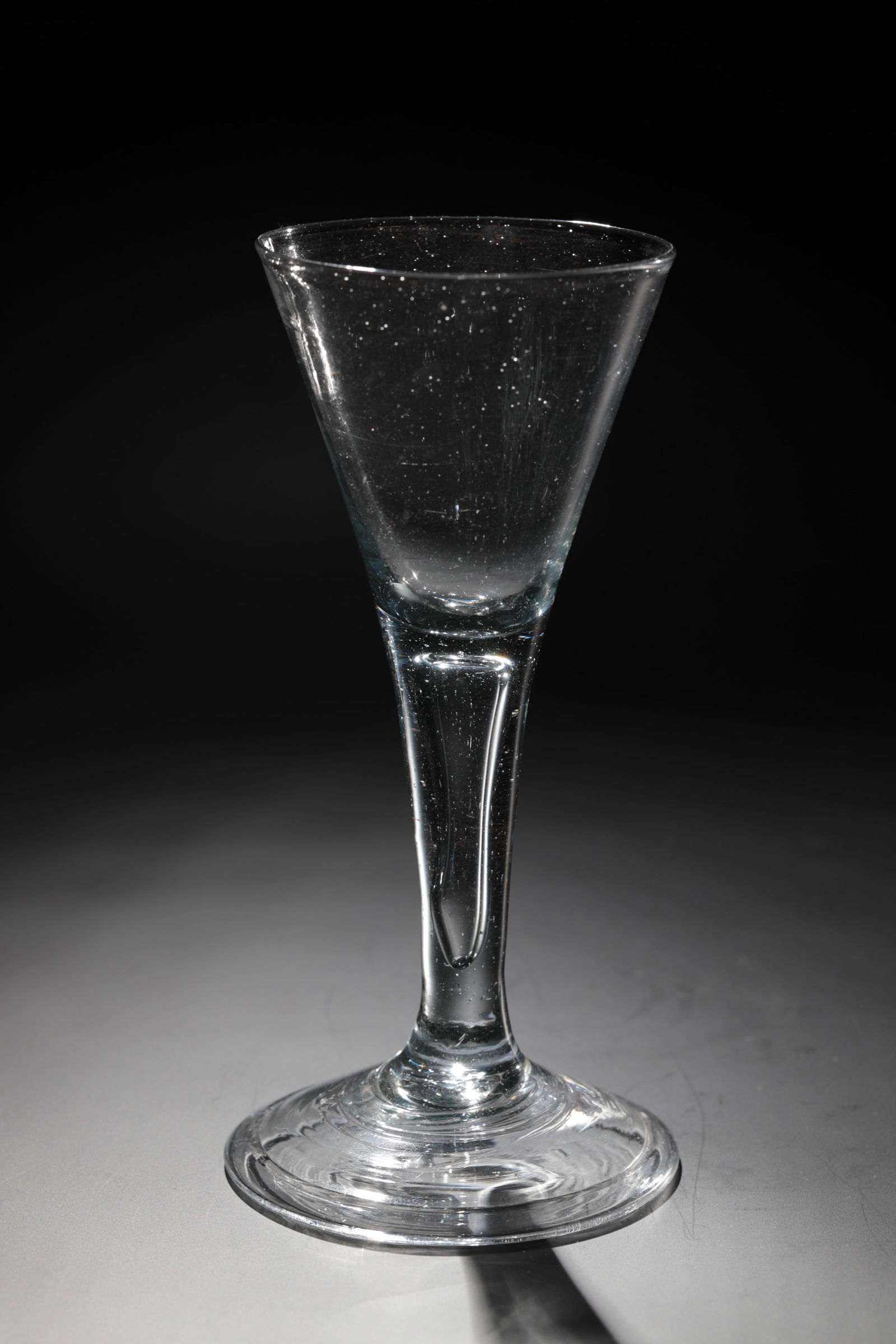 Goblet: Pointed chalice North German, 18th century Colourless glass with tear-off. Disc base with the edge folded downwards. hollow shaft merging into trumpet-shaped cuppa. H. 17.5 cm