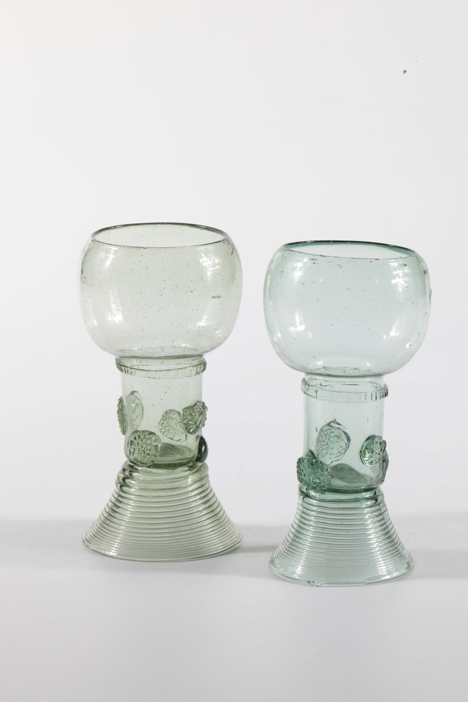 Two Romans: Two Romans German or Netherlands, 17th / 18th century Spun trumpet foot. Berry nubs applied to the shaft, which is open at the top. Below the bulbous cuppa, a placed, pinched glass thread runs