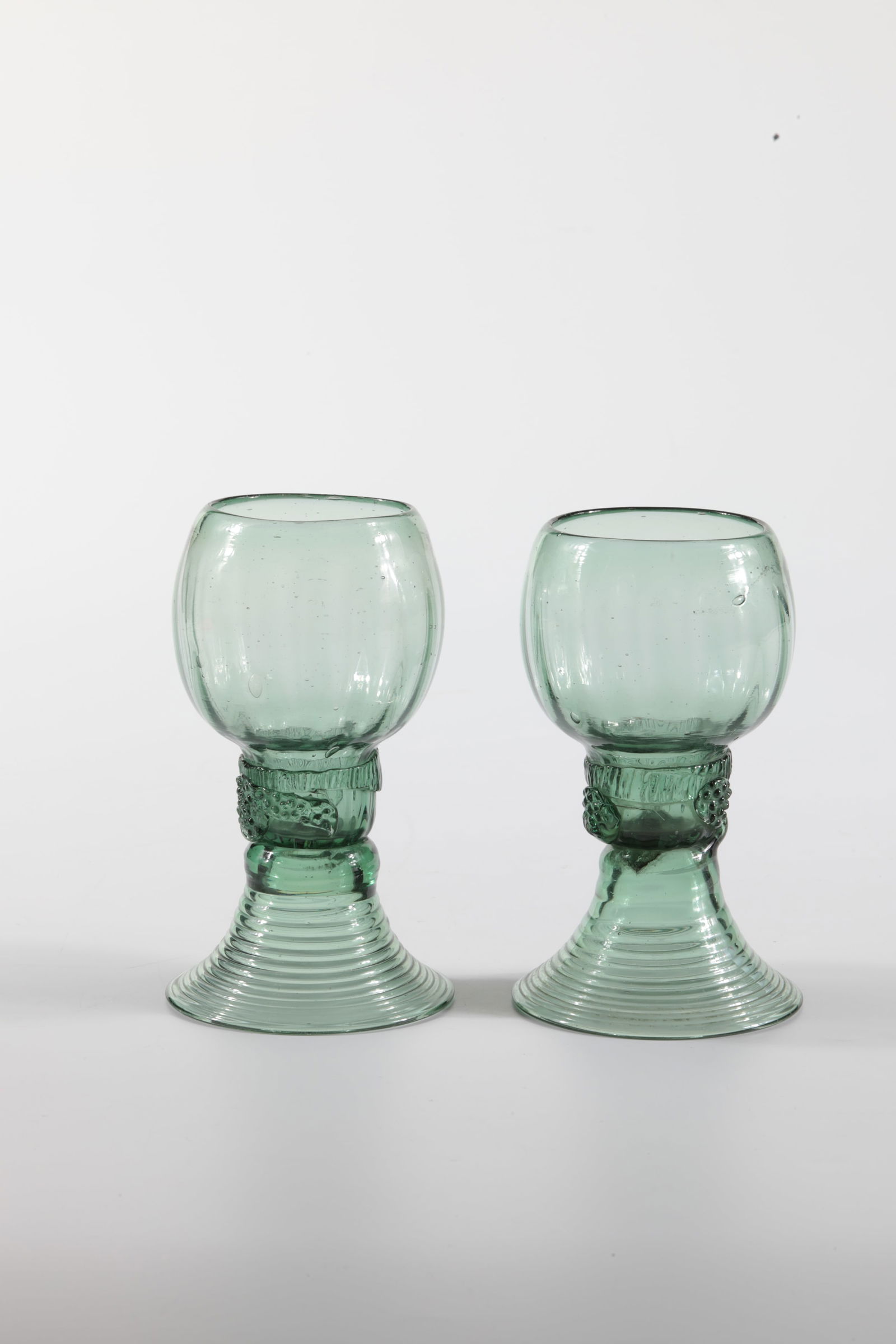 Pair of Romans: Pair of Romans German, 17th / 18th century Green glass with tear-off. On the shaft, which is open at the top, three appliquéd berry nubs. Below the ribbed, bulbous cuppa, circumferential, pinched