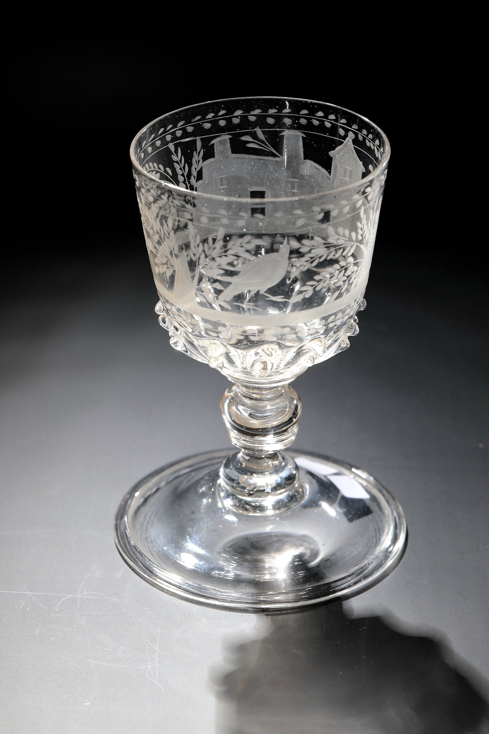 Cup: Goblet Bohemia, E. 17th century Colourless glass with tear-off. Wide disc base with upturned edge. Short shaft with ball nodus between four disc nodi. At the base of the cuppa, a wreath of melted ribs