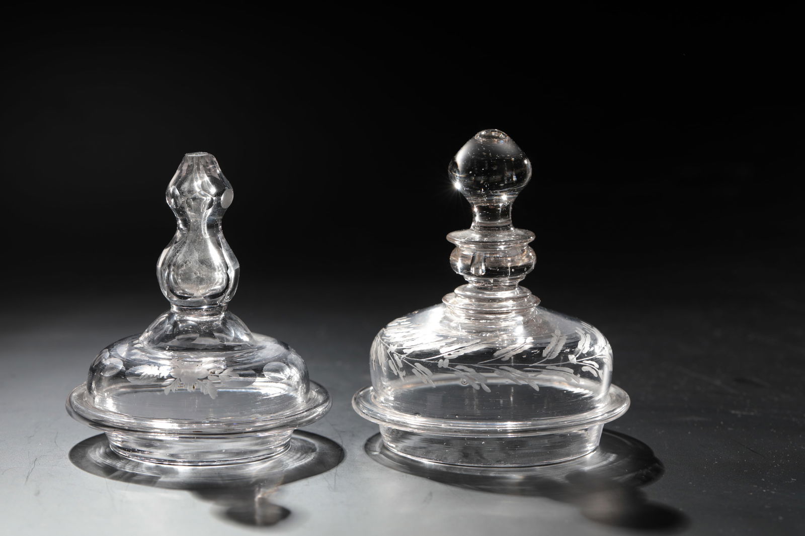 Two baroque lids: Two Baroque lids, Bohemia, 18th century, colourless glass with cut decoration. Ball knobs partly faceted. D. Inner rim 6.7 or 5.4 cm