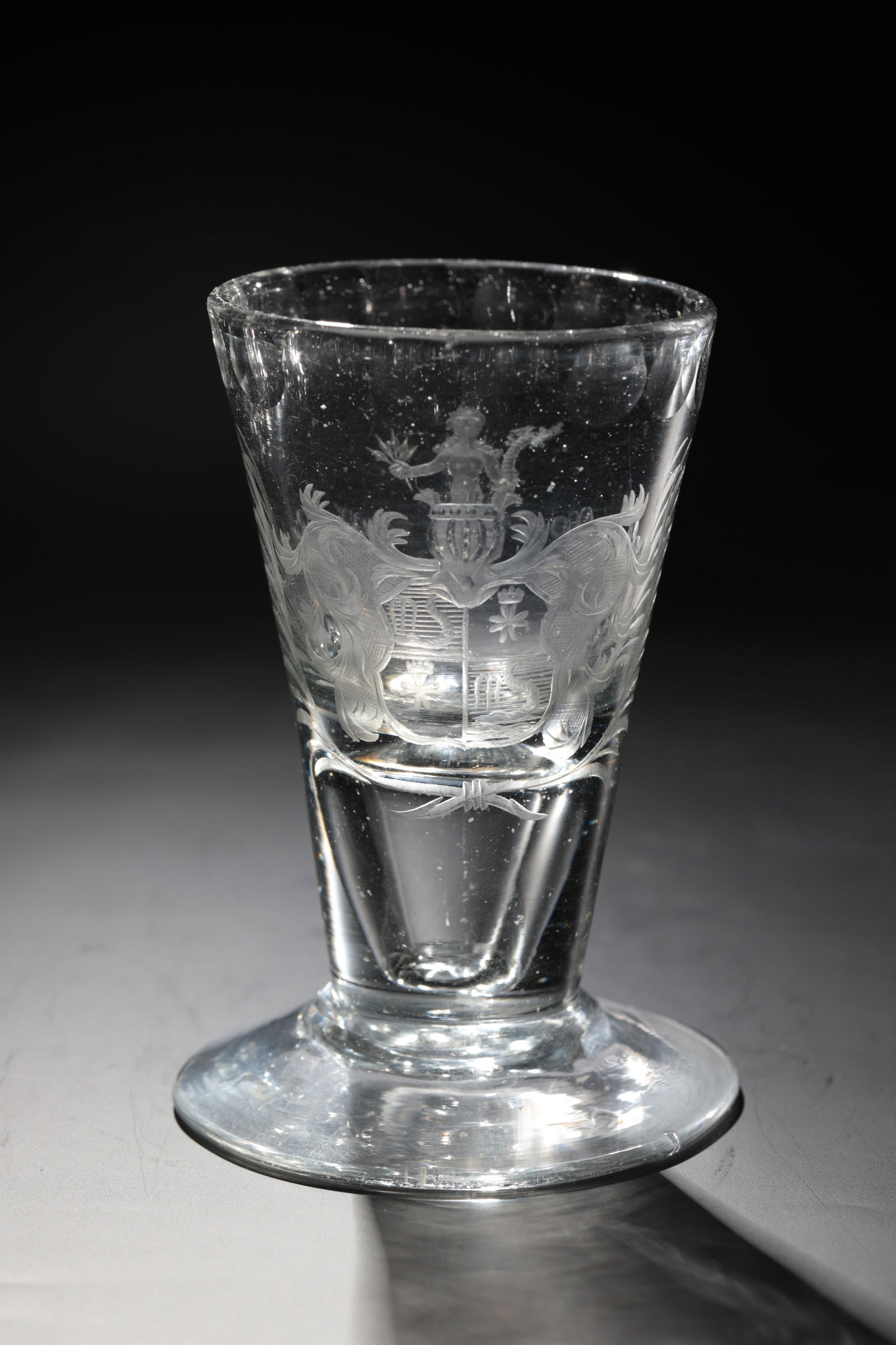 Goblet with coat of arms: Goblet with coat of arms of Northern Germany, 18th century. Slightly greyish glass. Disc base with ground tear-off. hollow shaft merging into conically widened wall. Frontal finely cut coat of arms