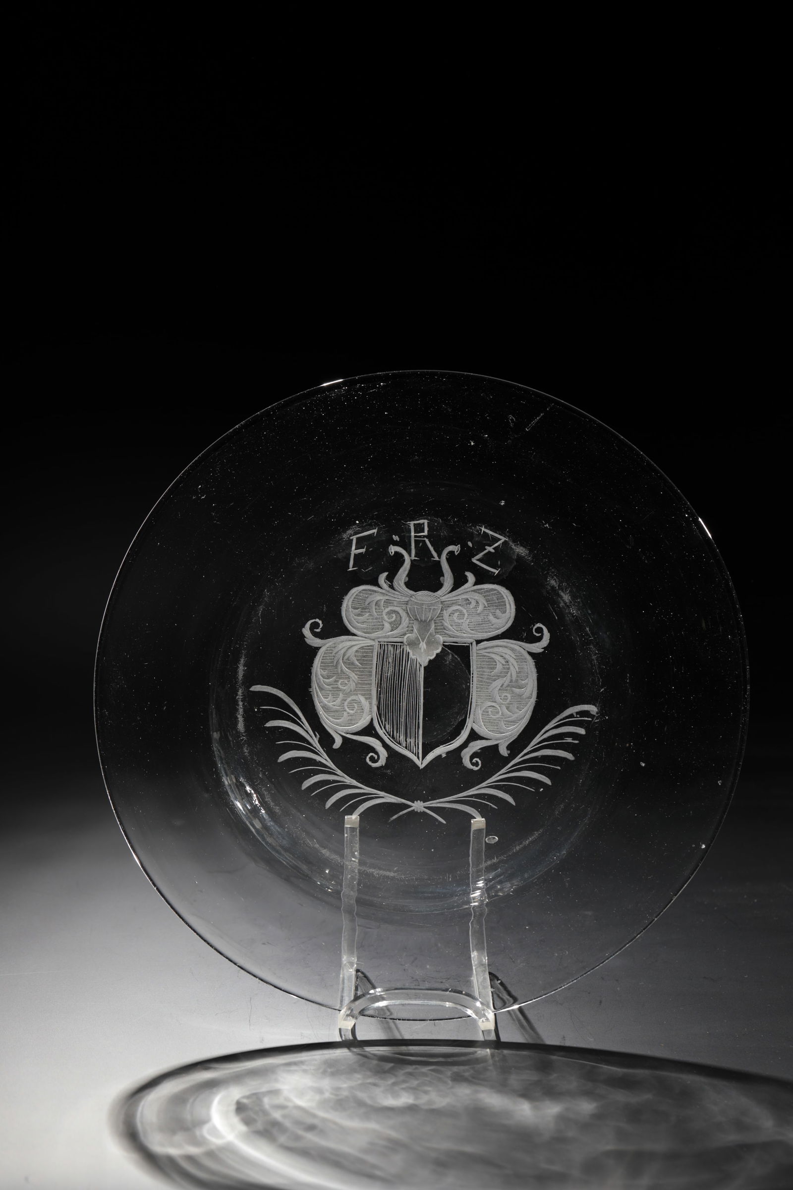 Plate: Plate Saxony or Bohemia, 18th century Colourless glass with ground tear-off. Coat of arms cut in the mirror over crossed palm branches, above initials ''FRZ''. D. 24.5 cm