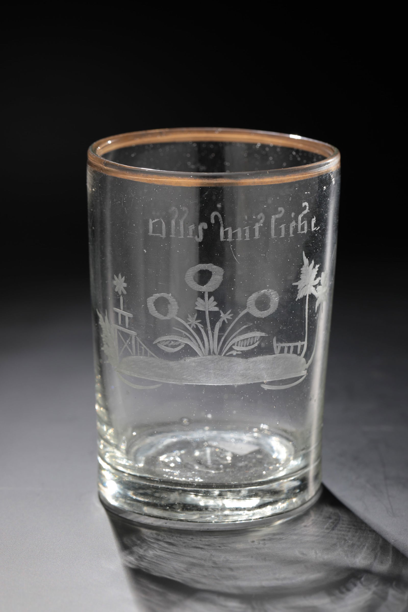 Mug with Allegory of Love: Beaker with allegory of love Weserbergland, 18th century Colourless glass with tear-off. Floral decoration cut on the front of the cylindrical wall and inscription: ''alles mit Liebe''. Gilded lip rim