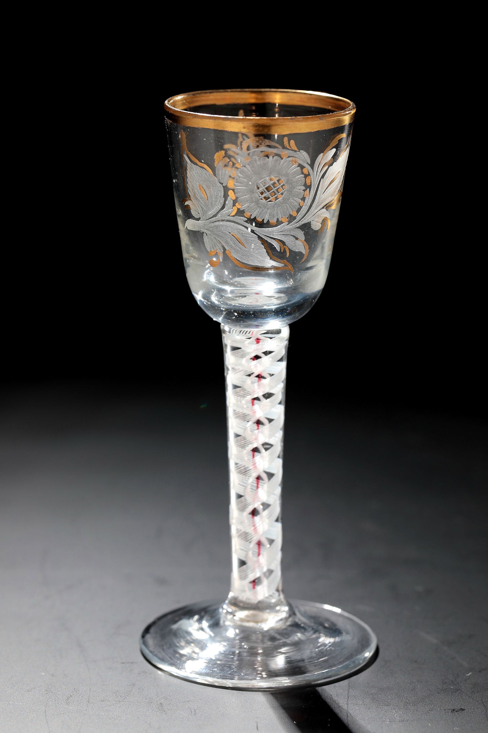 Filament glass: Thread glass Silesia, E. 18th century Colourless glass with tear-off. Disc base. Upper with incorporated milk and gold ruby threads. On the bell-shaped cuppa in matt cut, partly gold contoured a flowe