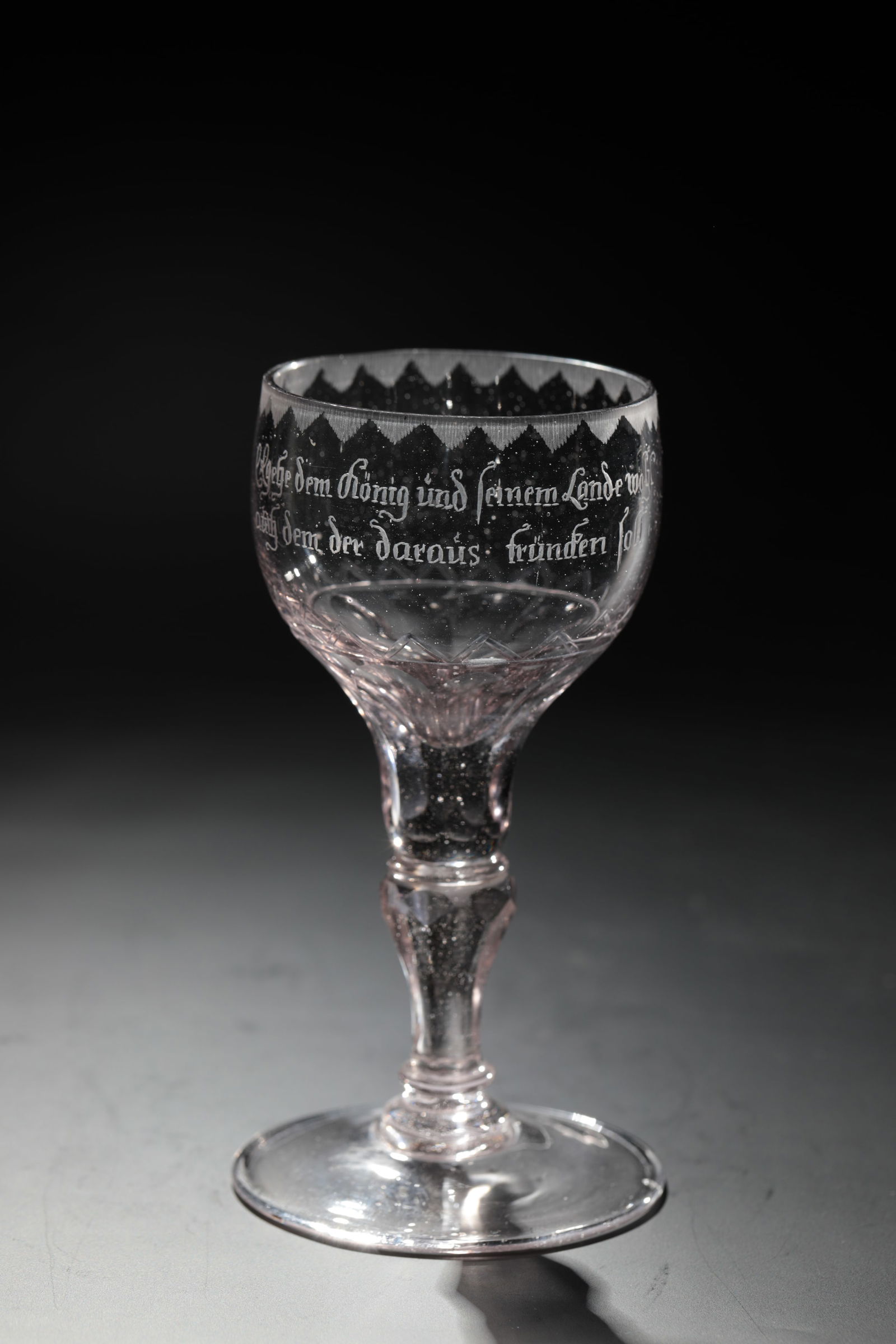 Small goblet glass with saying: Small goblet glass with motto Silesia, 18th century Colourless, slightly manganese-tinged glass. Disc base, faceted baluster shaft. Roots of the bulbous cuppa peeled. Frontal inscription: "May the kin