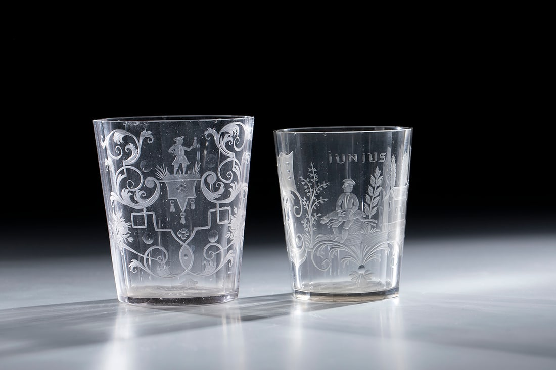 Two cups: Two cups Silesia, 18th century. Slightly greyish tinted glass. Demolition with sunflower decoration. In cross-section, oval, multi-faceted wall with an engraved depiction of a man surrounded by