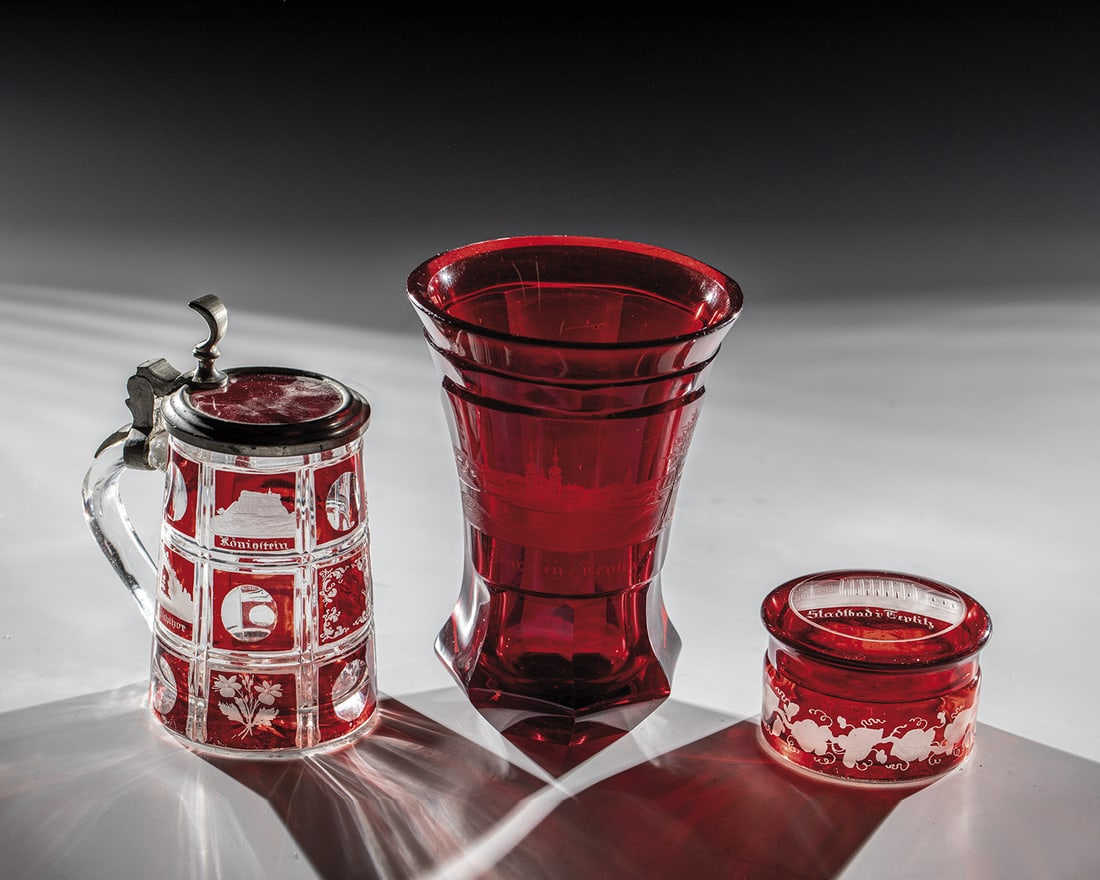 Mug jug, lidded box and mug with views of Teplice: Mug with handle, lidded box and mug with views of Teplice Bohemia, mid-19th century. Small jug with lid and small lidded box, colourless, red glazed glass, with cut views of Teplice as well as mug