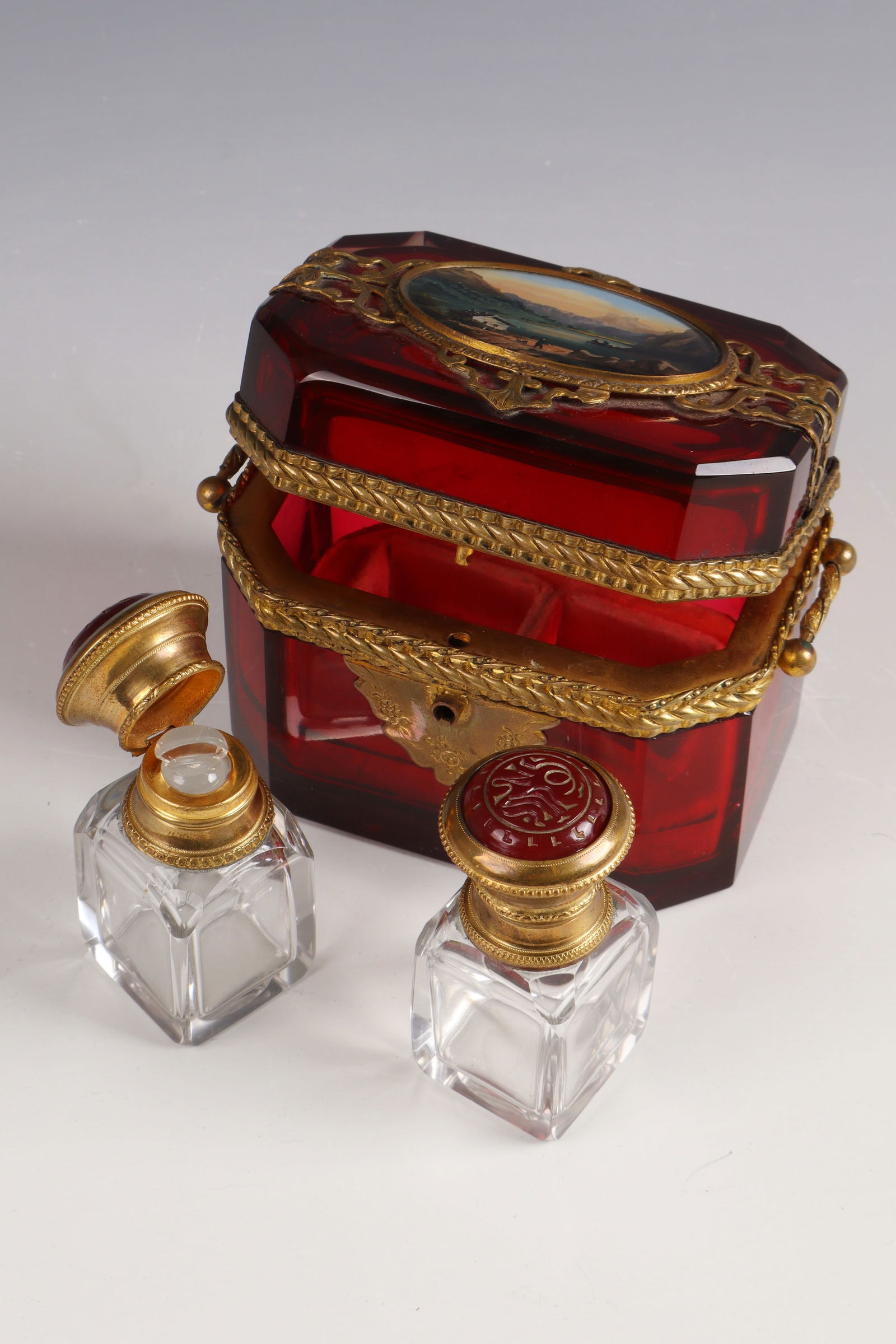 Lidded box with flacons and view of the Königsee: Lidded box with flacons and view of the Königsee, mid-19th century. Ruby-red glass with elaborately embossed metal frame. Inside two small flacons with stoppers and metal-mounted, red hinged cap in