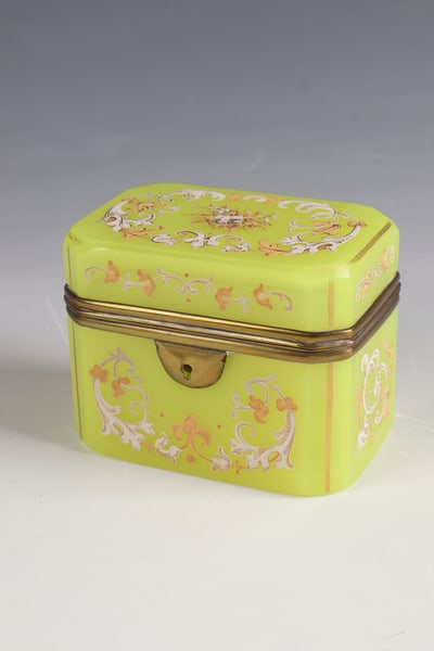 Lidded jar: Lidded box Bohemia, c. 1860 Anna-yellow glass (uranium glass) with ornamental tendril decoration in enamel and gold. Rectangular body with flattened edges. Metal-mounted. H. 8cm ,L. 10.5 cm.