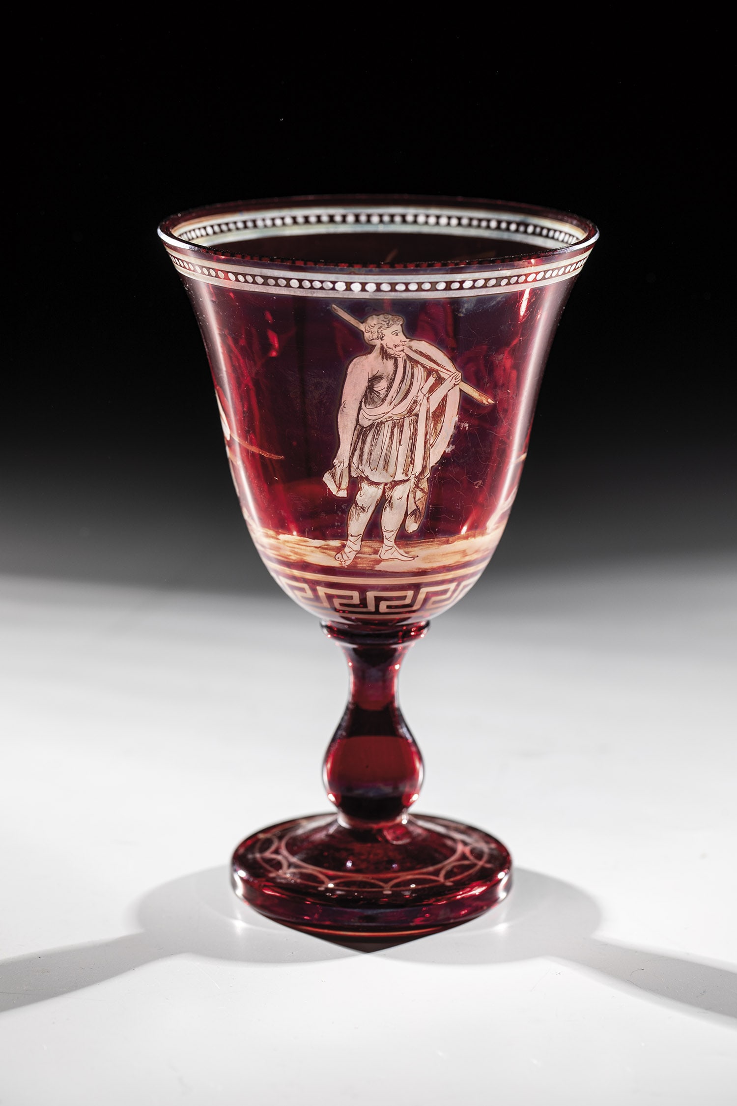 Cup: Karl Günther cup, Steinschönau, c. 1865 Colourless, red-glazed glass. On bell-shaped cuppa, depicting an ancient battle scene and ornamental decoration. H. 17 cm.