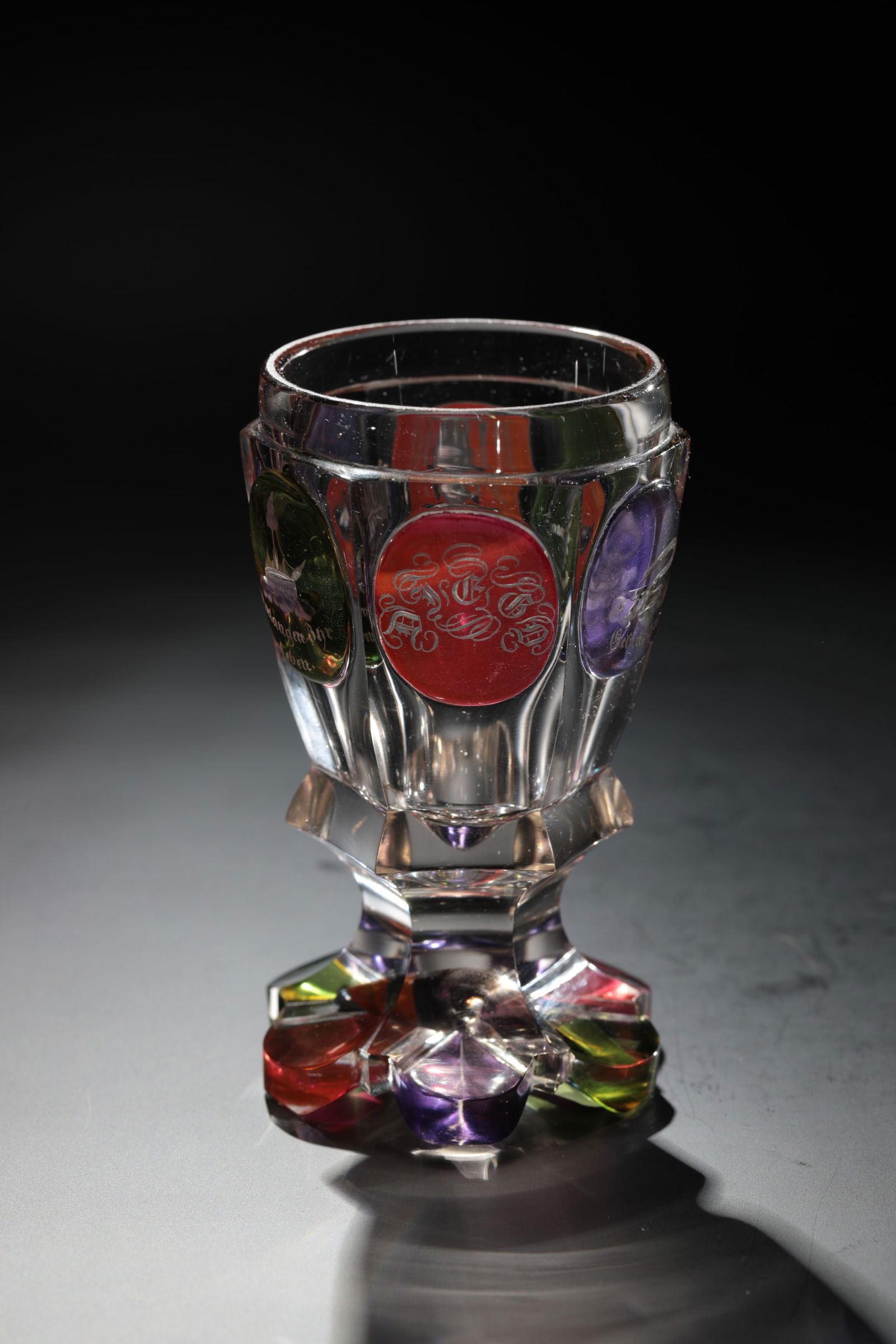 Foot cup: Foot cup workshop of Friedrich Egermann, Blottendorf or Haida, North Bohemia, around 1840 Colourless, partly green, rosalin and purple glazed, richly cut glass. On the faceted wall, allegorical