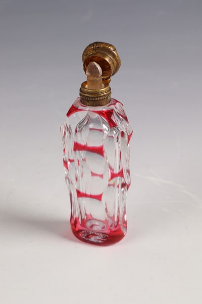 Perfume bottle: Perfume bottle France, 19th century Colourless glass with gold ruby overlay with rich lentil-cut decoration. Vermeil mount on hinge. H. 8.5 cm
