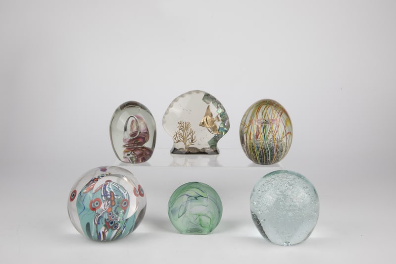 Six paperweights: Six paperweights 20th/21st century An acrylic paperweight with fish motif and original label ''Genuine Paua Shell'' as well as five glass paperweights. One of them with original label ''Hokitika Glass