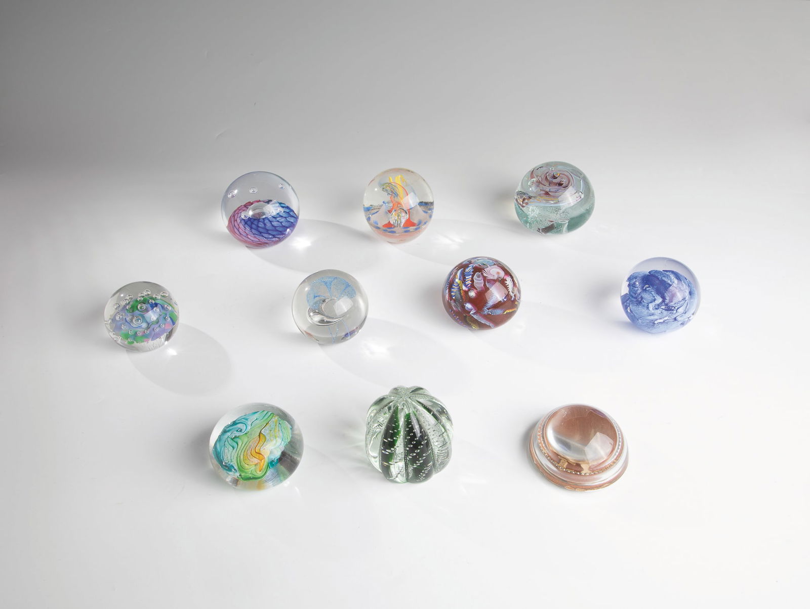 Ten Paperweights: Ten paperweights 20th century Ten paperweights made of glass with different motifs and without signature. A paperweight with signature ''Fusion Glass''. D.6.9-8.7cm H.4.0-7.5cm.