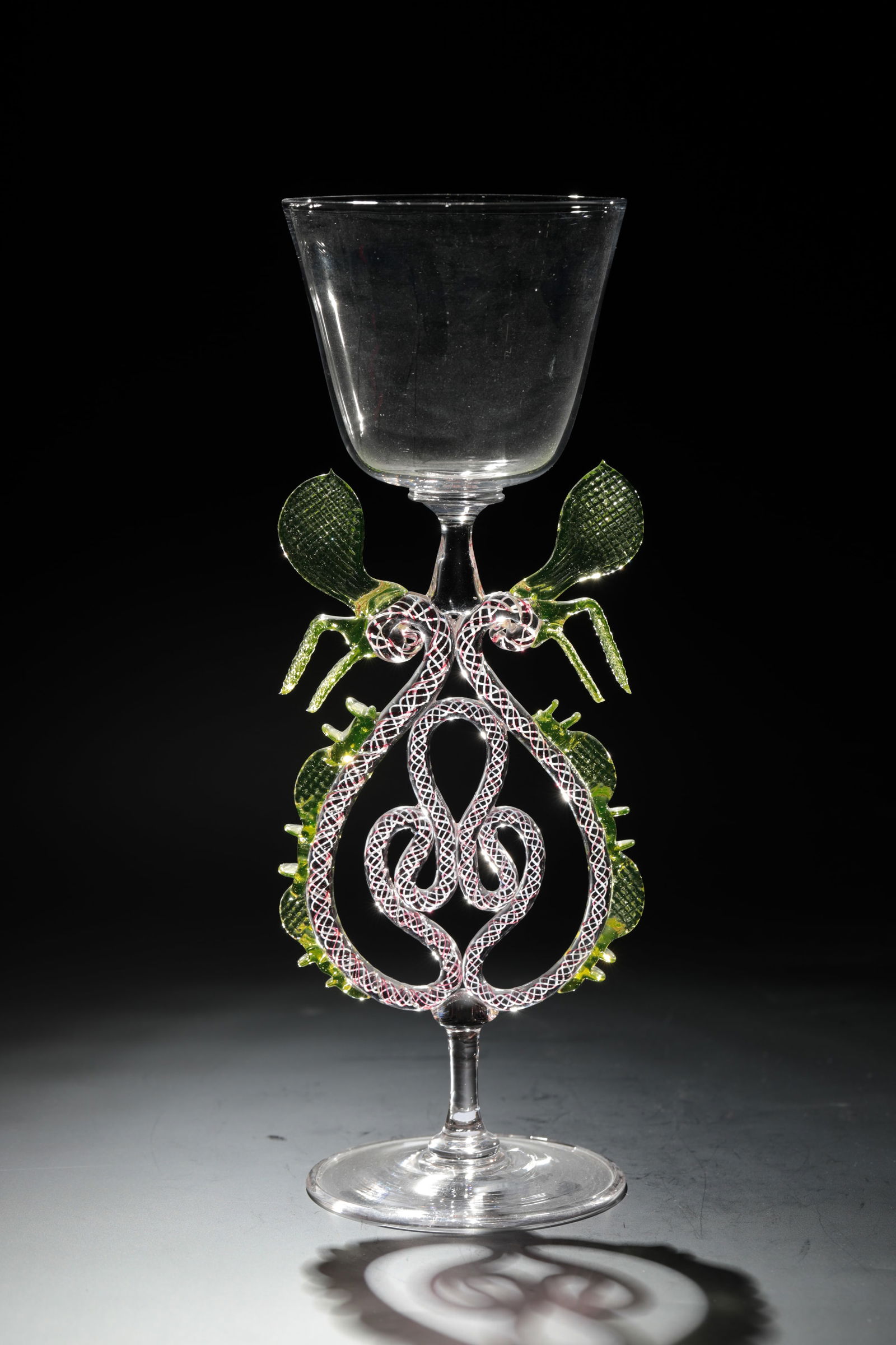 Large sash glass: Large winged glass Rheinische Glashütten AG, Cologne-Ehrenfeld, around 1881 Colourless glass. Pinched decorations and wings made of uranium glass, the inner spiral threads of the stem in red and