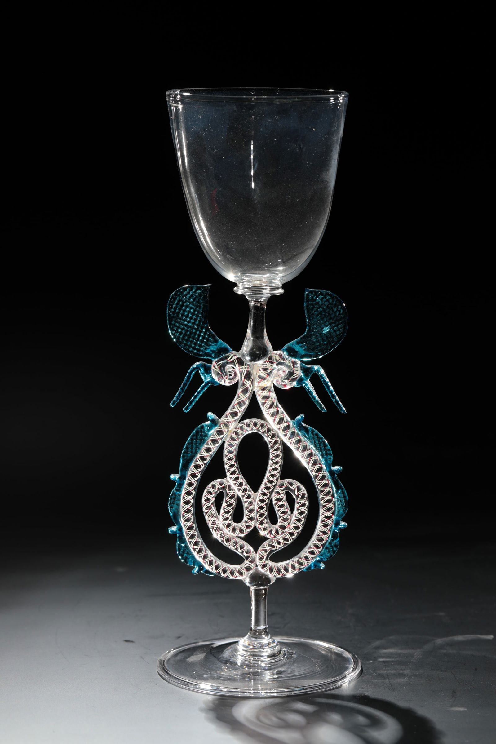 Large sash glass: Large winged glass Rheinische Glashütten AG, Cologne-Ehrenfeld, around 1881 Colourless glass. Pinched decorations and wings in blue glass, the inner spiral threads of the stem in red and white. H: