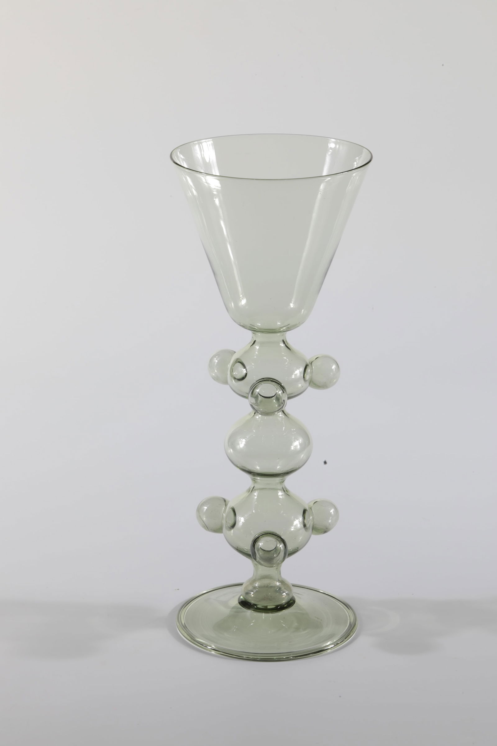 Puzzle Cup: Puzzle goblet Rheinische Glashütten AG, Cologne-Ehrenfeld, around 1881 Olive-coloured glass. Three hollow-blown nubs at the upper and lower ends of the hollow stem. Etching stamp Ehrenfeld. H: 26.5 c
