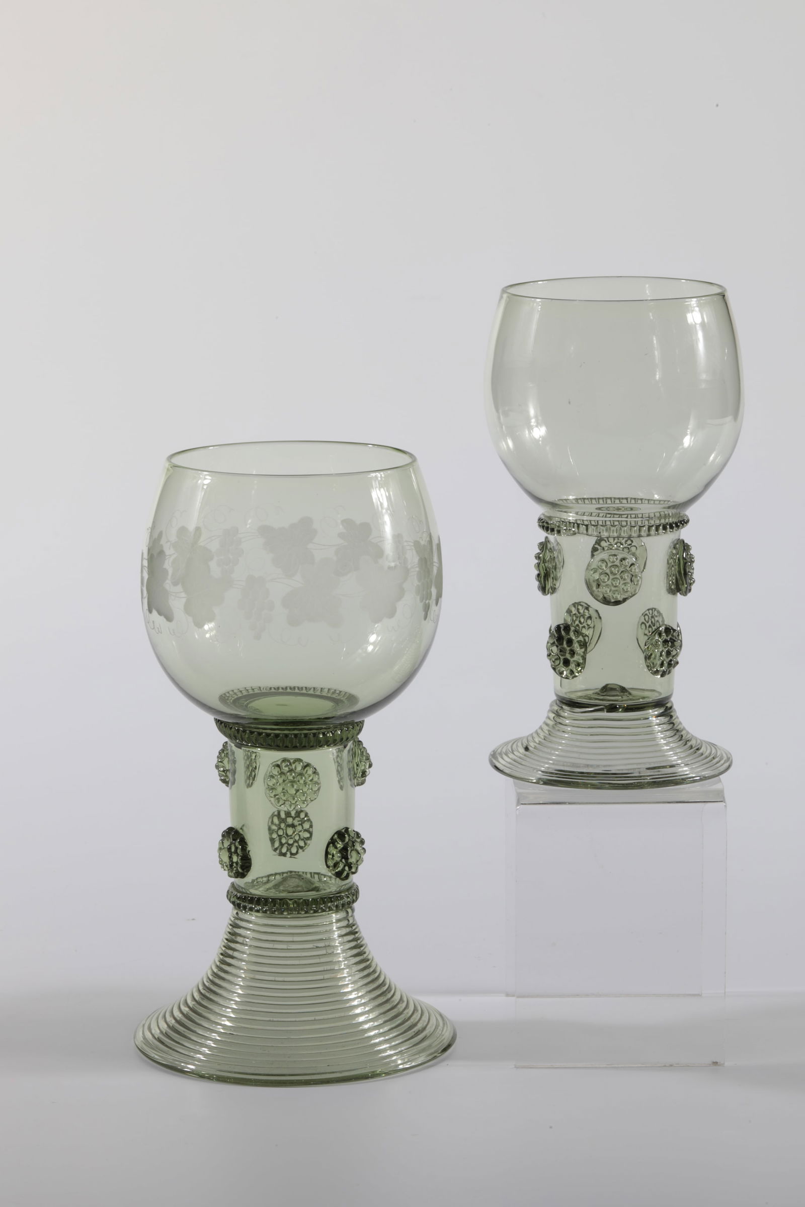 Two Romans Wallenstein and Maximilian: Two Römer Wallenstein and Maximilian Rheinische Glashütten AG, Cologne-Ehrenfeld, around 1881 Antique green glass. Ribbed thread, six or eight nubs and spun foot. One with vine leaves. H: 15 cm or 1