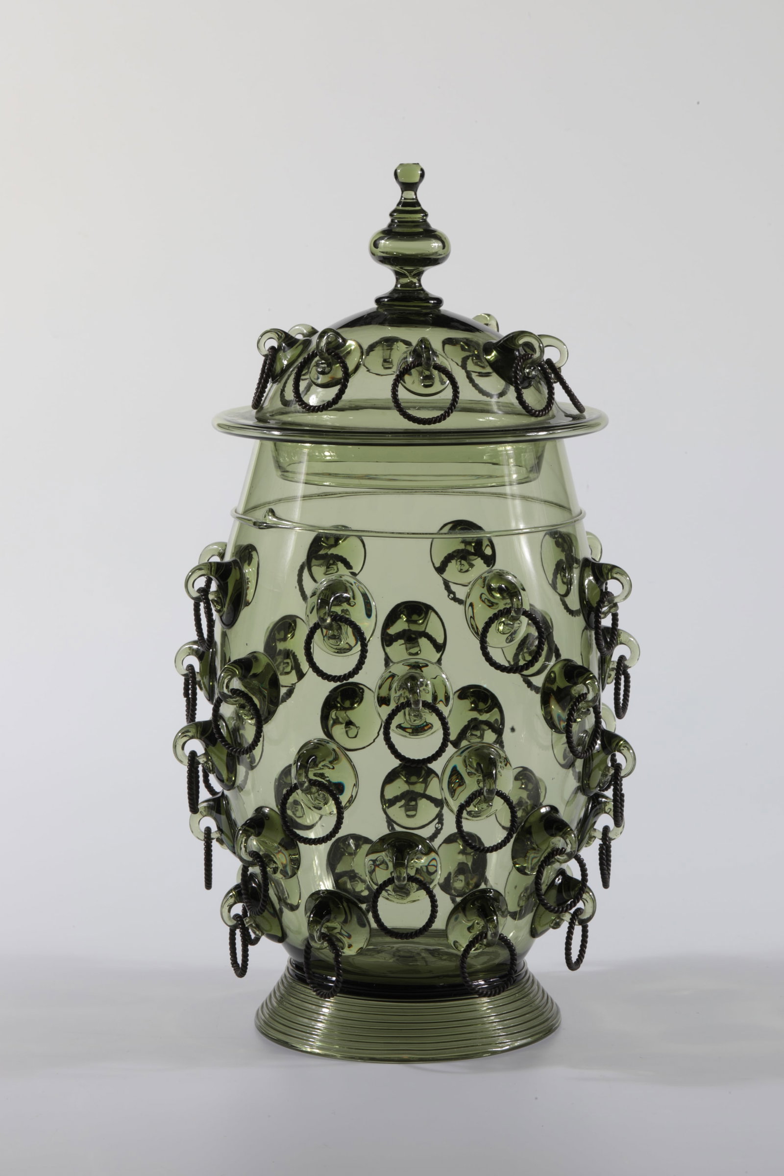 Ringed tankard with lid: Ringed tankards with lid Rheinische Glashütten AG, Cologne-Ehrenfeld, around 1881 Ringed tankards with lid. Green glass, folded thread, with nubs and brass rings. One brass ring on the lid and three