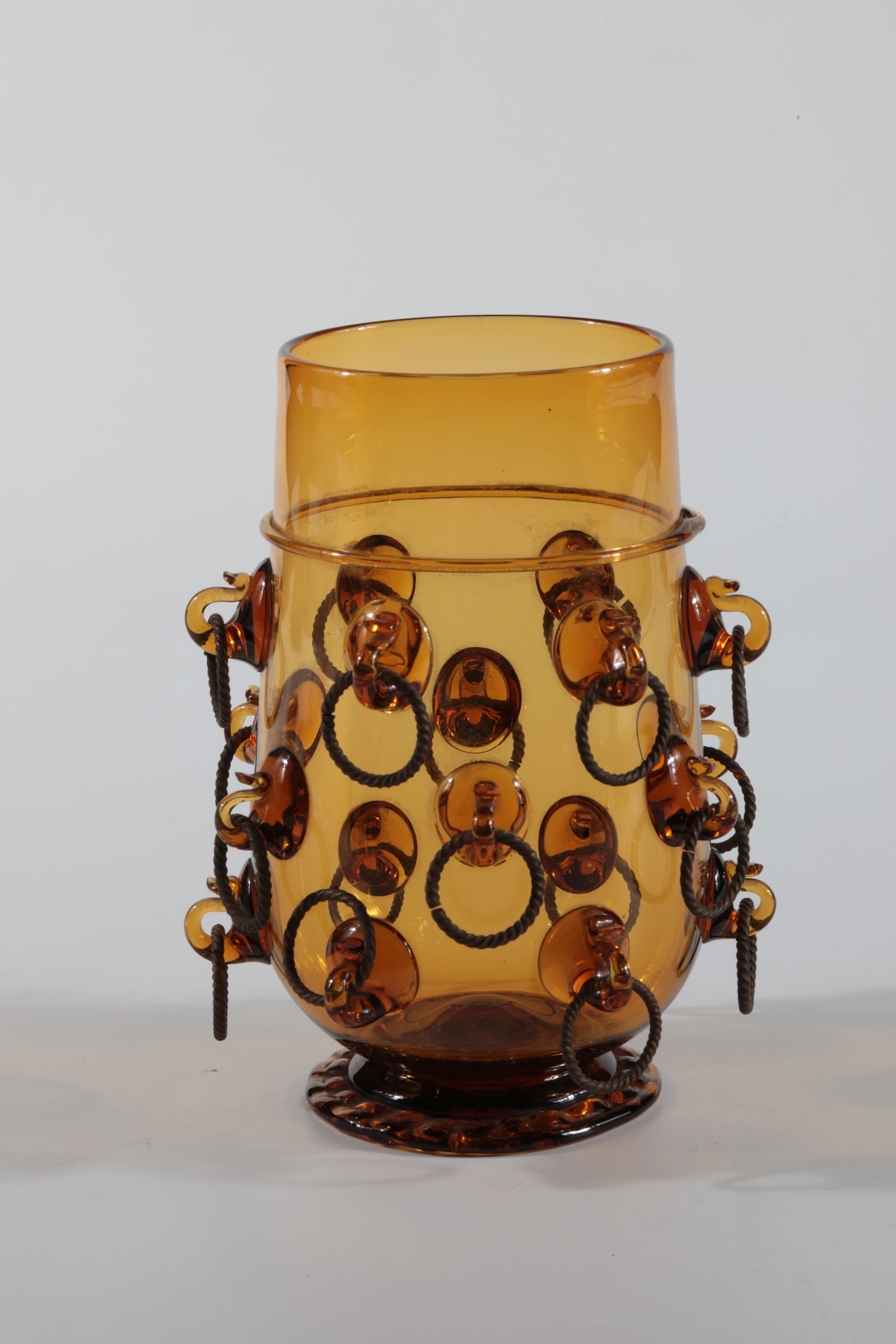 Edo May Wine Hümpchen: Edo-Maiwein-Hümpchen Rheinische Glashütten AG, Cologne-Ehrenfeld, around 1881 Edo-Maiwein-Hümpchen, amber-coloured, brass rings. H: 12.5 cm.
