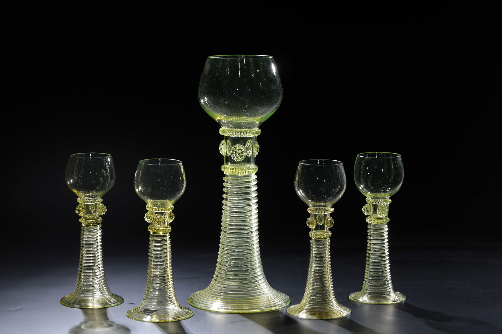 Six punch glasses ''Freya'': Six punch glasses ''Freya'' Rheinische Glashütten AG, Cologne-Ehrenfeld, around 1881 Light green glass. Five nubbles in the shape of a star, threaded at the neck, ribbed handle. H: 8 cm.