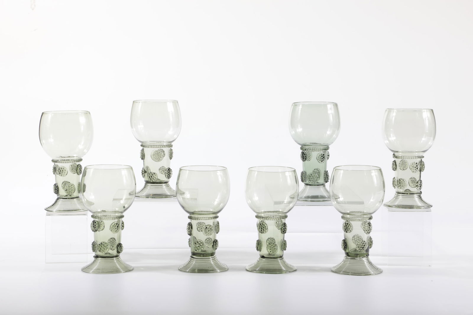 Romans: Römer Rheinische Glashütten AG, Cologne-Ehrenfeld, around 1881 Green glass. Kuppa ribbed crosswise, ribbed thread and four nubs. Foot spun. H: 15.5 cm.