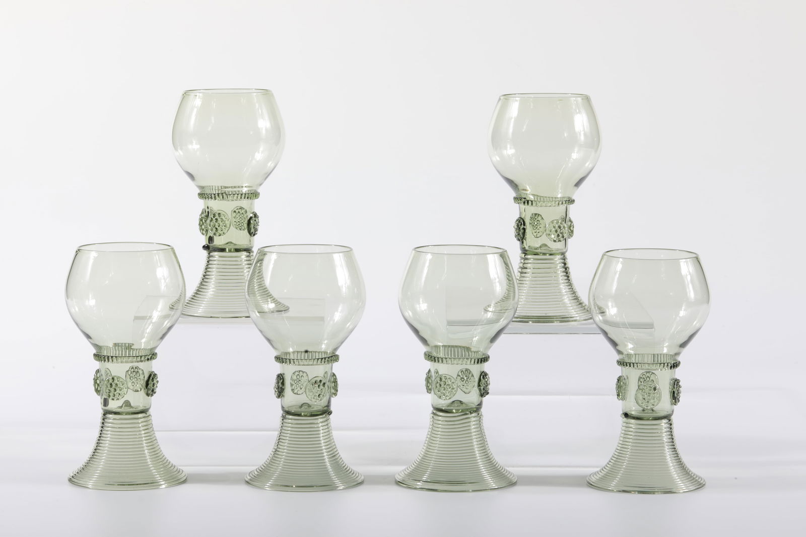 Set Six Romans: Set six Römer Rheinische Glashütten AG, Cologne-Ehrenfeld, around 1881 Antique green glass. Ribbed thread and four nubs, foot spun. H: 12 cm.