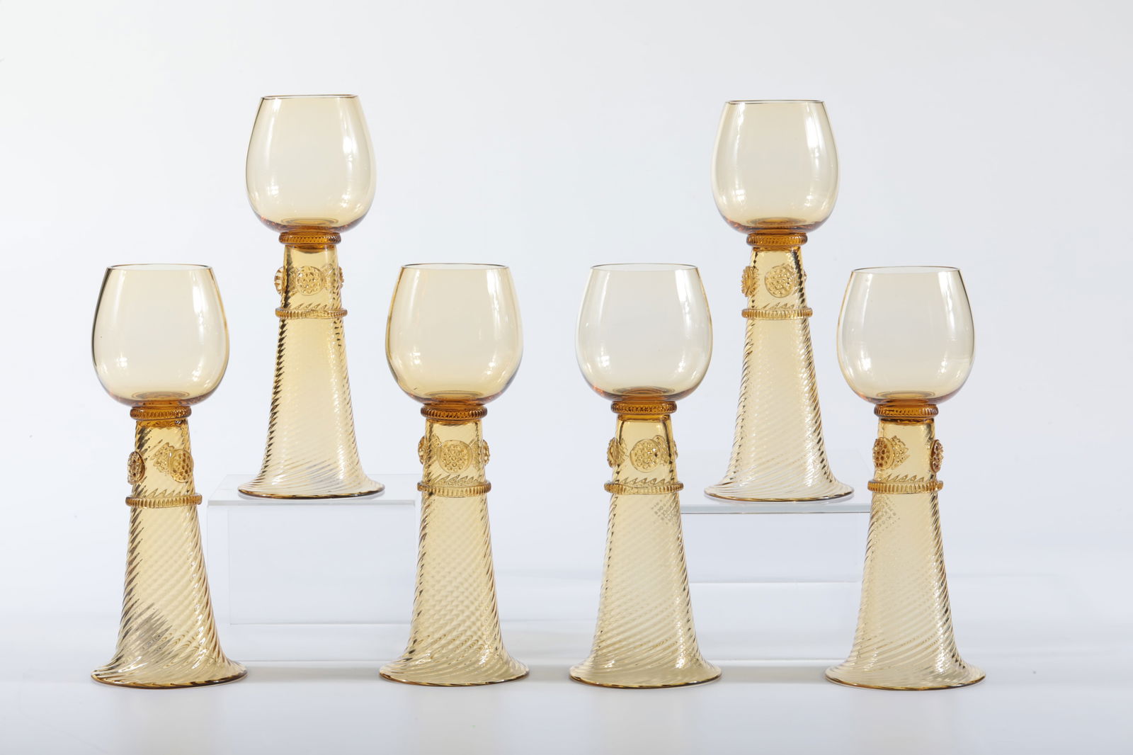 Set of six Hutten-Römer: Set six Hutten-Römer Rheinische Glashütten AG, Cologne-Ehrenfeld, c. 1881 Yellowish glass. Two ribbed threads and three flat nubs on a high ribbed foot. H: 20 cm.