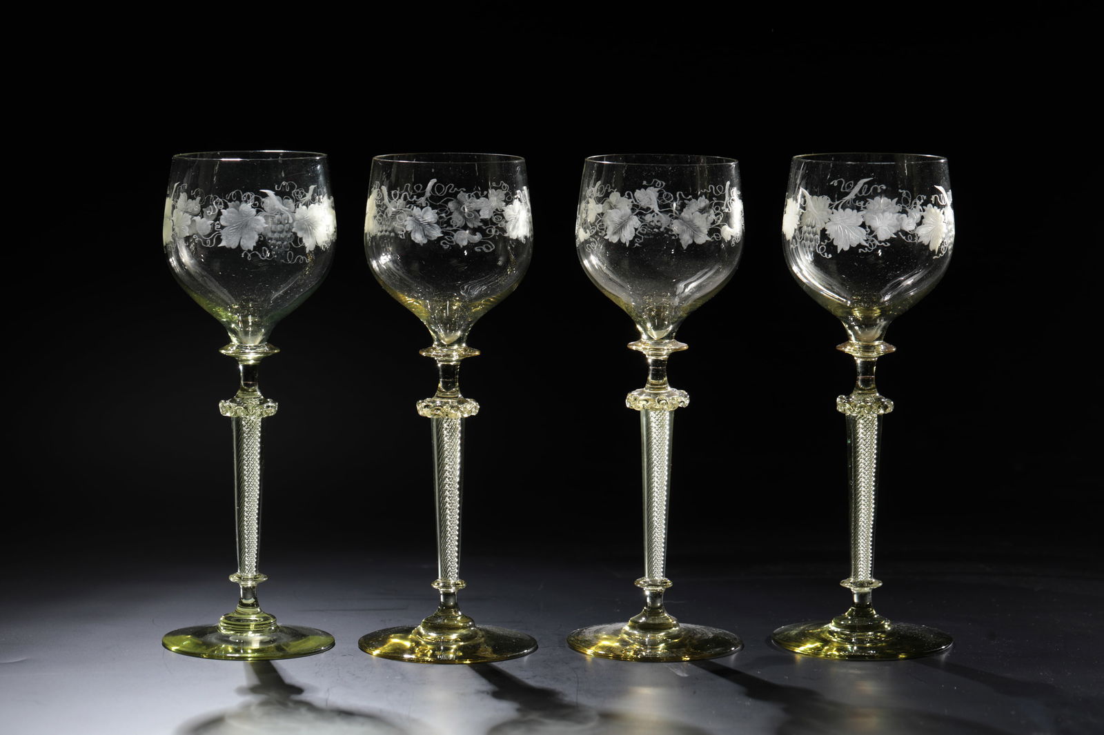 Four Romans Rhinegold: Vier Römer Rheingold Rheinische Glashütten AG, Cologne-Ehrenfeld, c. 1881 Moss-green glass. Stem with spiral air stripes and curled choker, engraved with vine leaf tendrils. H: 19 cm.