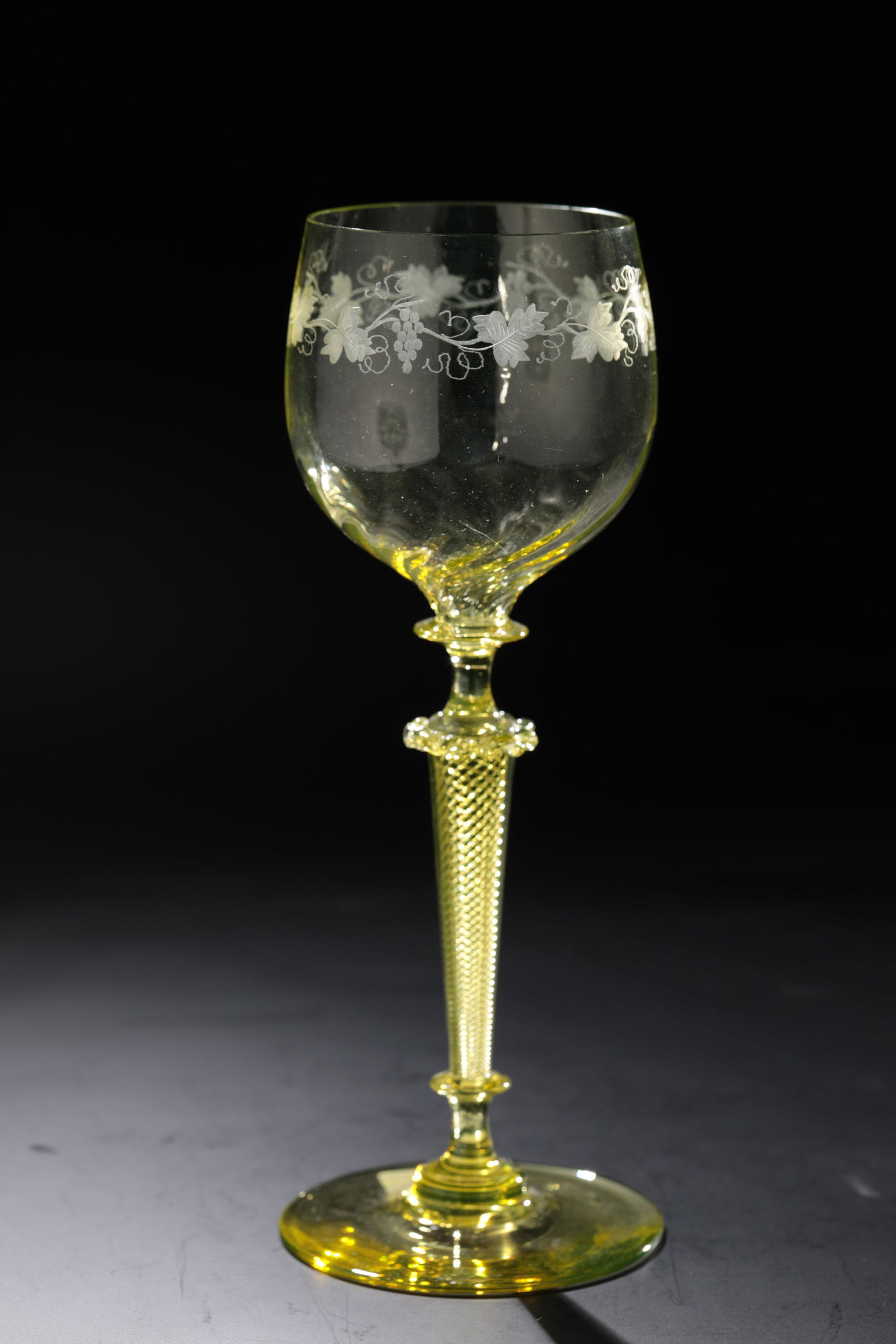 Romans: Römer Rheinische Glashütten AG, Cologne-Ehrenfeld, around 1881 Yellowish-moss-green glass. Stem with spiral air stripes and curled choker. Godroned cuppa with engraved vine vine tendril. H: 19 cm.
