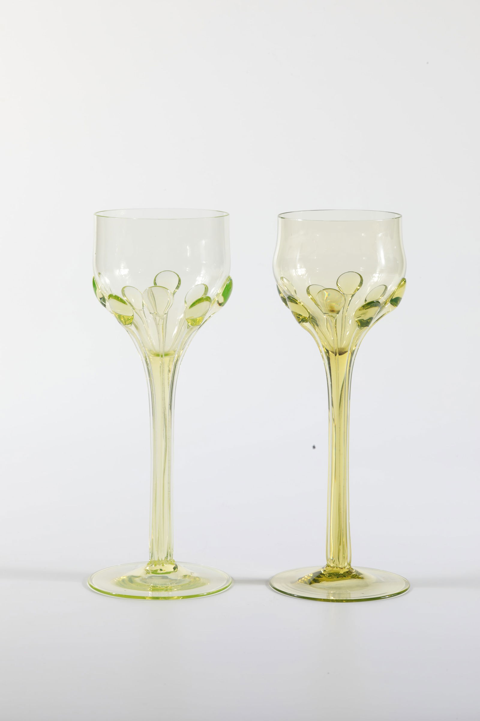 Two goblets: Two goblet glasses Rheinische Glashütten AG, Cologne-Ehrenfeld, around 1881 Uranium glass. With applied, elongated drops from the tip end to the toe. H: 20.5 cm.