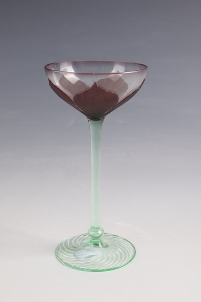 Liqueur glass: Liqueur glass Rheinische Glashütten AG, Cologne-Ehrenfeld, ca. 1902 Spiral-optically ribbed base and stem shaft made of light green glass. The colorless cuppa with overlay in dark purple. Etched
