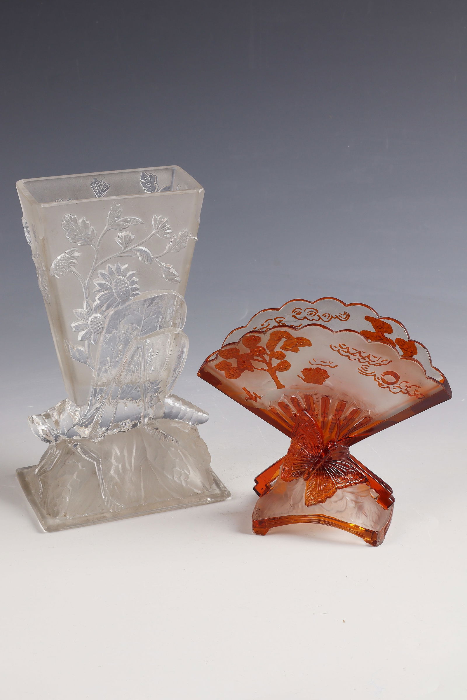 2 Vases ''Locuste'' - ''Éventail'': 2 vases ''Locuste'' - ''Éventail'' Cristalleries de Baccarat, 1878 Colourless, partly amber-overlaid glass, moulded, refinished by polish. H. 20 and 13.5 cm lit.: G. Cappa, Le Genié Verrier de