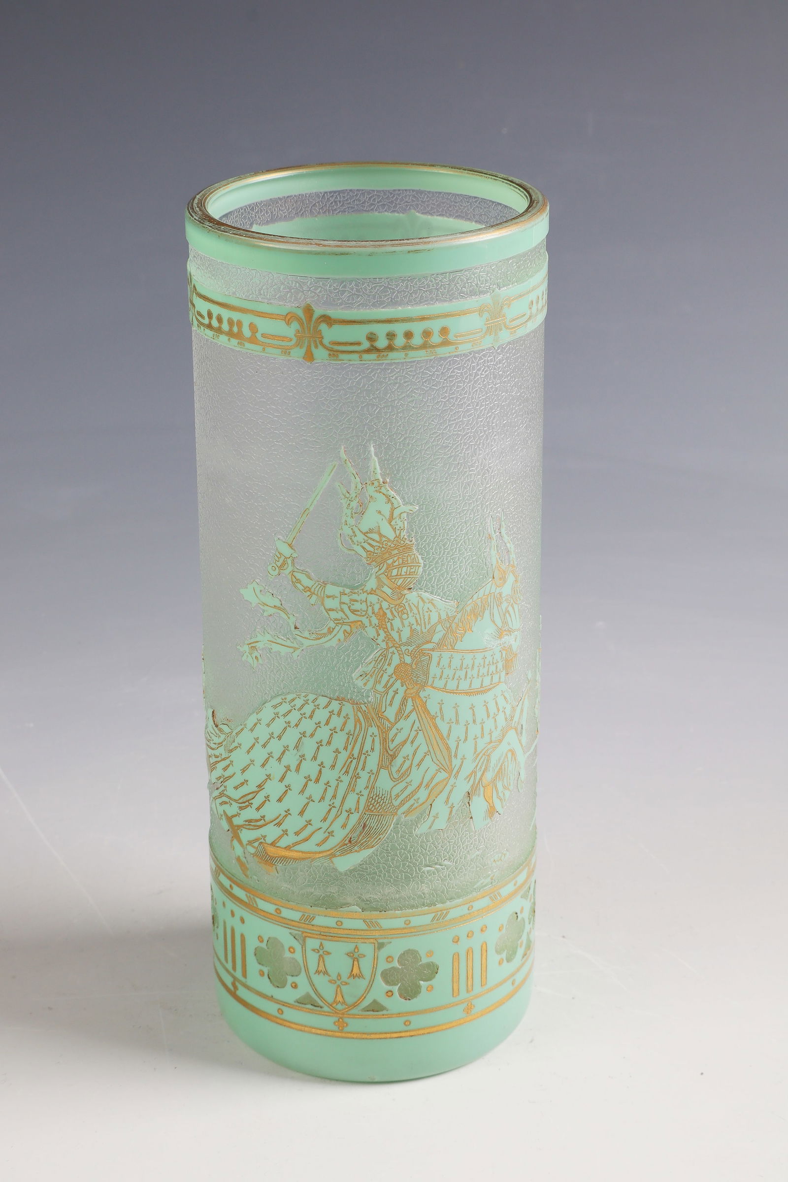 Cylinder vase ''Tournoi'': Cylinder vase ''Tournoi'' Cristalleries de Baccarat, 1900 - 1910 Colourless glass, turquoise overlay. Relief etched décor. Interior drawing in gilded needle etching. H. 20 cm Lit.: G. Cappa, Le