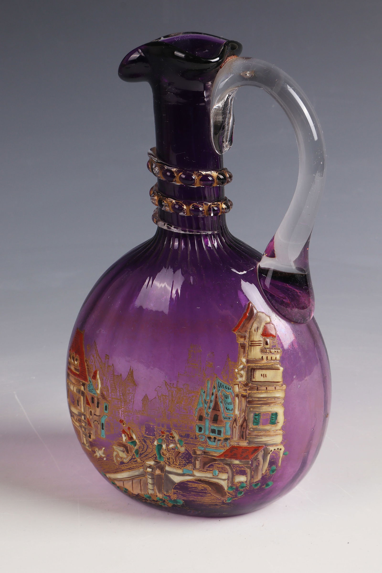 Jug with city view ''Paysage citadin'': Jug with city view ''Paysage citadin'' Cristallerie de Clichy, 1878 - 1890 Violet underpinned, colourless glass, colourfully enamelled and gilded. Attached handle and thread support in colourless.