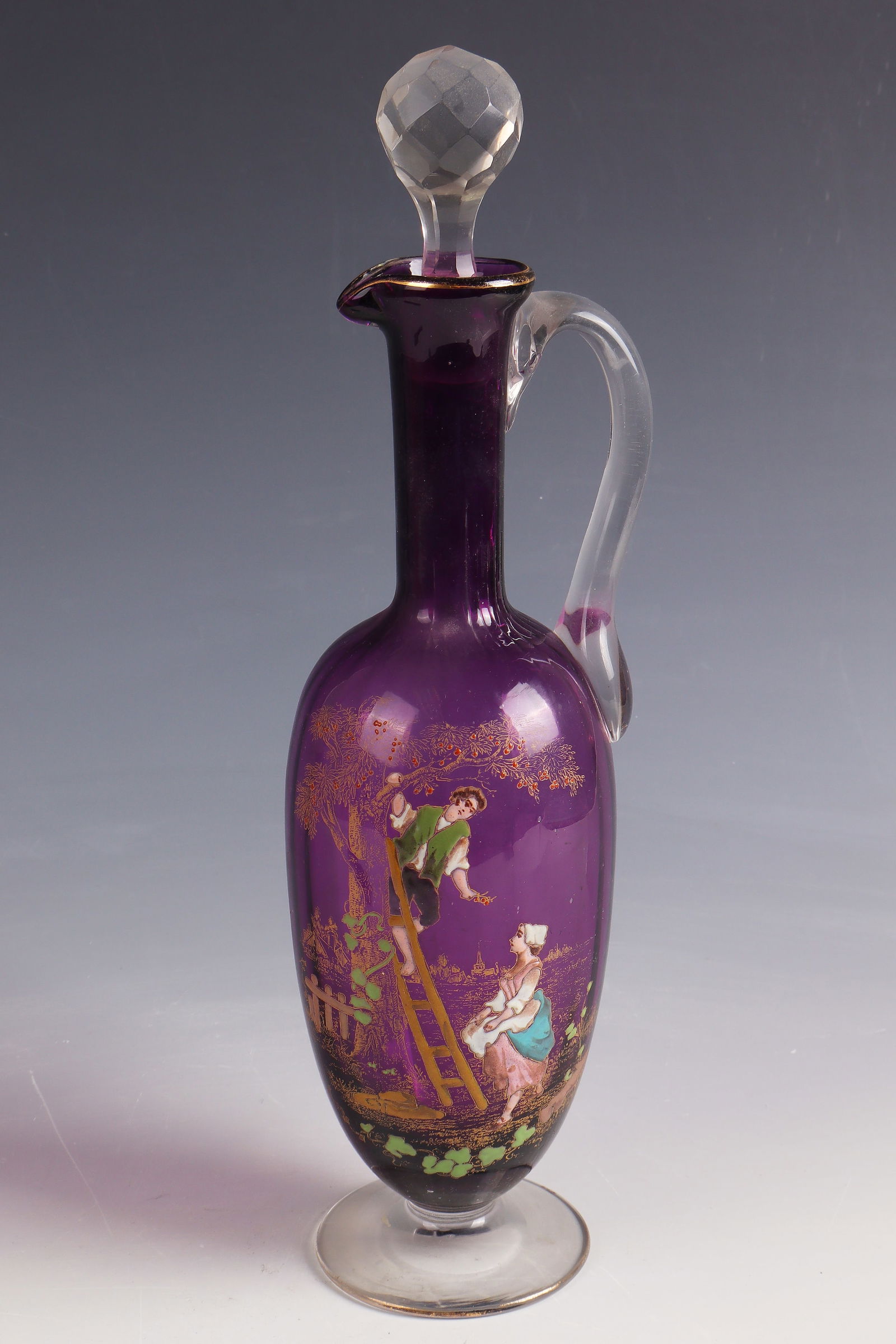 Handle carafe with stopper ''La cueillette des cerises'': Handle carafe with stopper ''La cueillette des cerises'' Cristallerie de Clichy, 1890 - 1900 Colourless, violet underpinned glass with gold and colourful opaque enamel decoration. H. 32 cm Lit.: G.