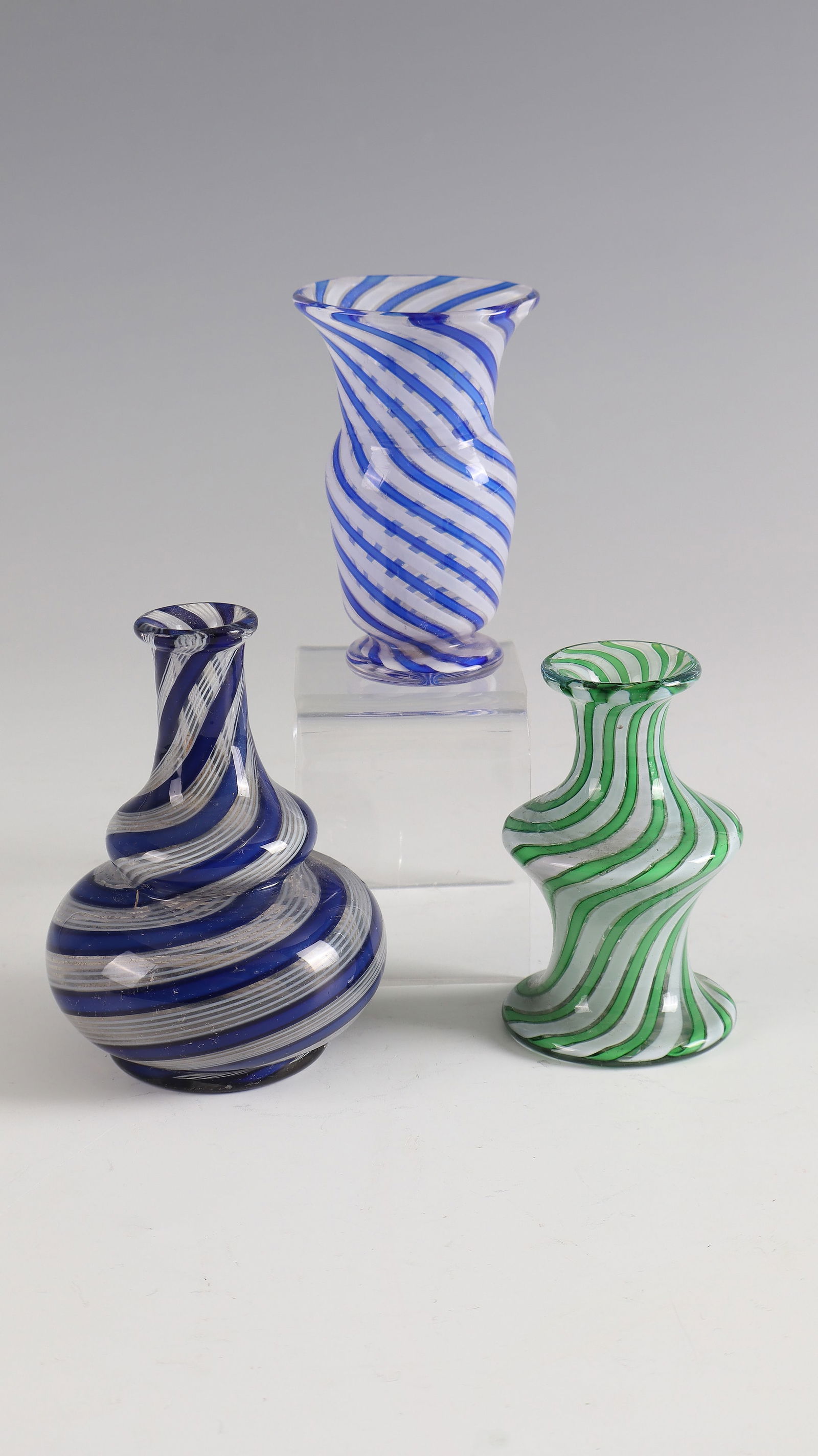 3 small vases ''Couleurs de Clichy'': 3 small vases ''Couleurs de Clichy'' Cristallerie de Clichy, around 1850 Colourless glass with diagonally melted coloured glass rods. H. 7.5 - 9 cm Lit.: G. Cappa, Le Genié Verrier de l'Europe, ed.: