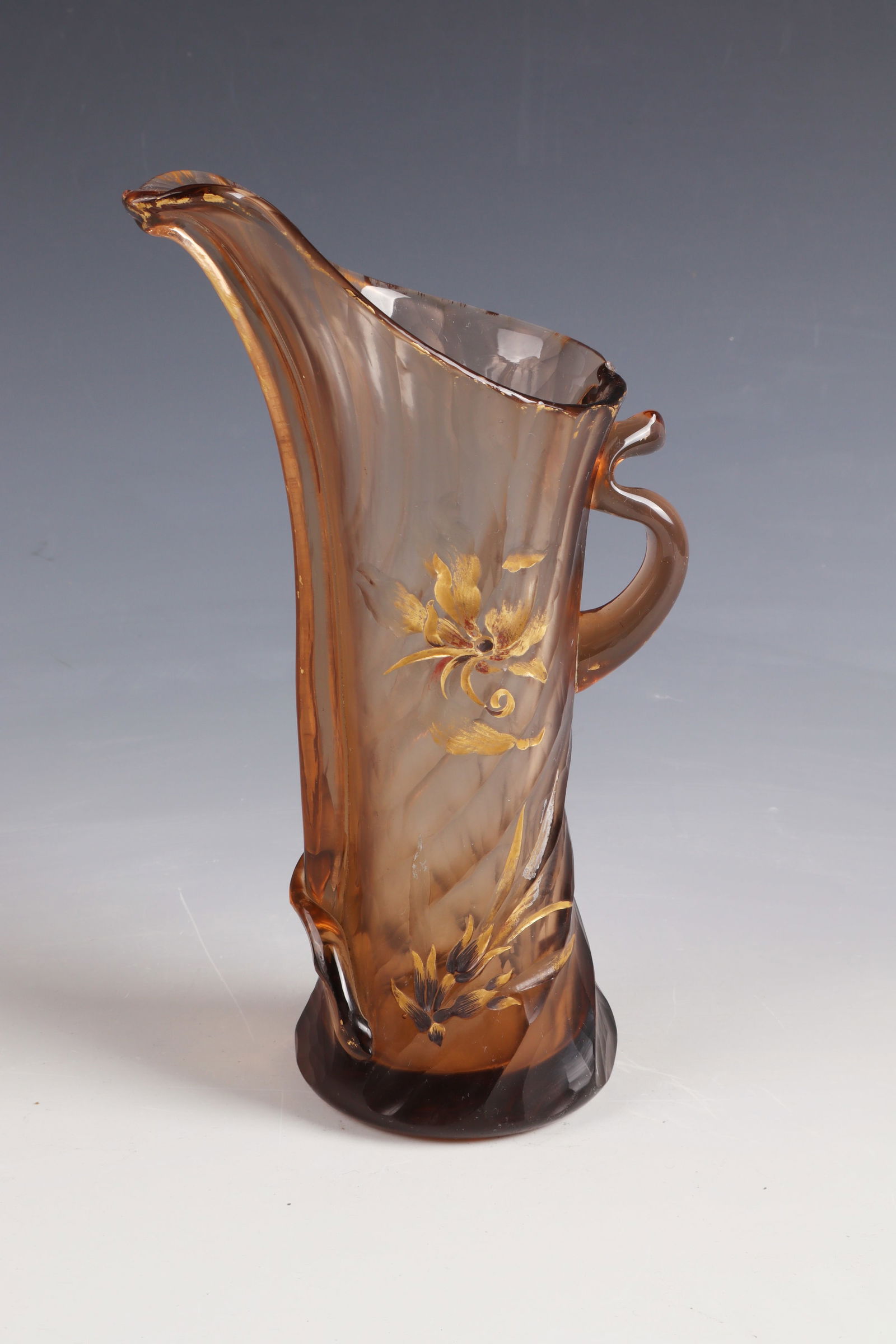 Jug ''Feuille de bananier'': Jug ''Feuille de bananier'' Emile Gallé, Nancy, c. 1888 Smoky brown glass, cut, engraved and gilded. Handle freely attached. Underside inscribed: Cristallerie d'Emile Gallé Nancy Modèle et décor