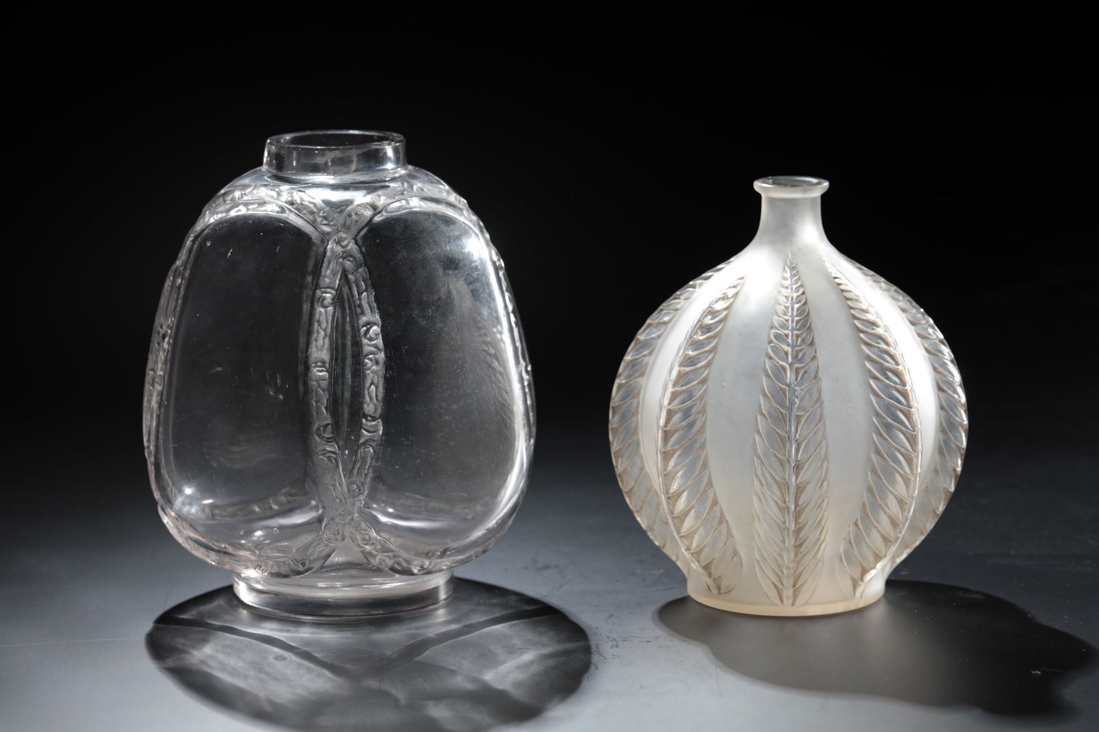 2 vases ''Guirlande de roses'' and ''Malines'': 2 vases ''Guirlande de roses'' and ''Malines'' René Lalique, Wingen - sur - Moder, 1914 and 1924 respectively Colourless glass, moulded, refinished by cutting and polishing. Ref.: R. LALIQUE