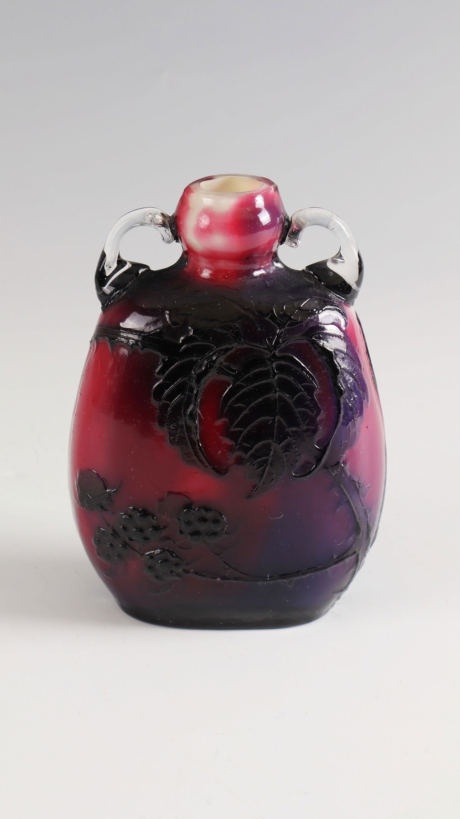 Handle vase with blackberry branch ''Mures'': Handled vase with blackberry branch ''Mures'' Muller Frères, around 1900 Colourless glass, with beige opal underlay, ruby pink and violet overlay. Relief etched décor. Interior drawing in high