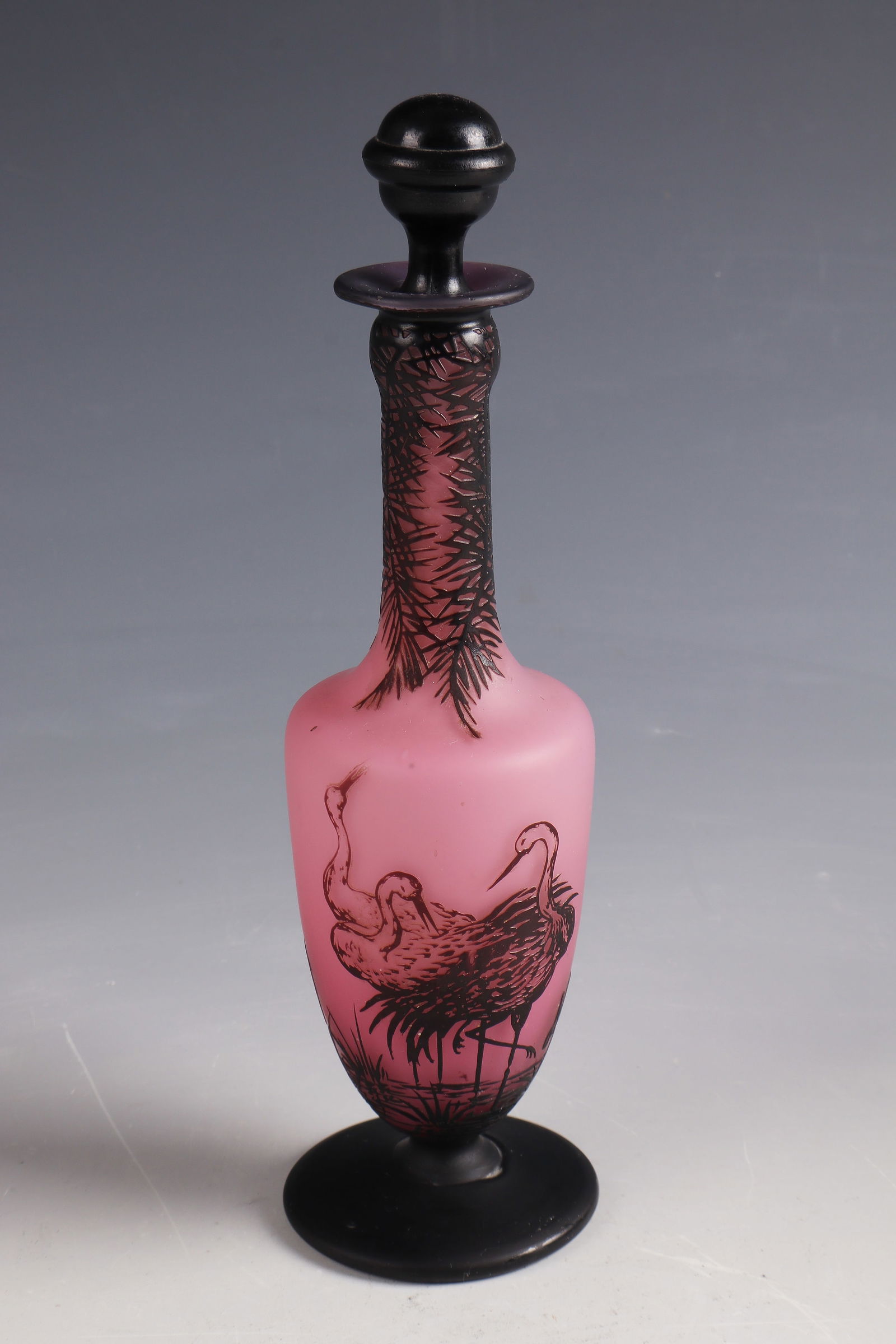 Bottle with stopper ''Les grues'': Bottle with stopper ''Les grues'' Cristallerie de Pantin, 1908 - 1910 Colourless glass, opaque pink underlay, violet overlay. Relief etched décor: cranes. On the wall inscribed: de Vez (etched). H.