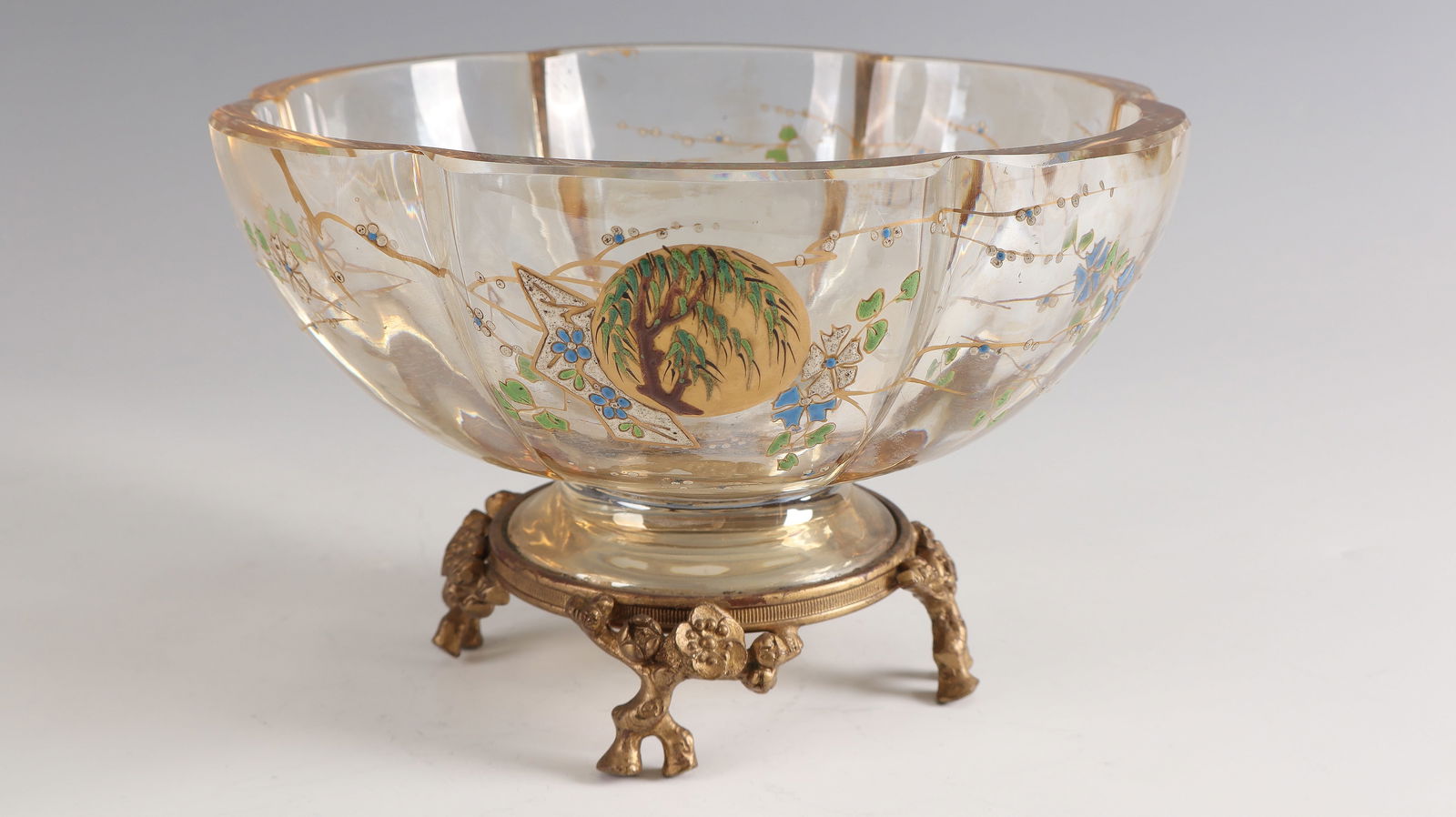 Foot bowl with japonizing decoration: Foot bowl with japonizing decoration Francois-Eugène Rousseau, Paris, 1878 - 1884 Light brown-yellow glass with colorful opaque enamel and gold painting. Gilded bronze mount. H. 12.5 cm; D. 20 cm