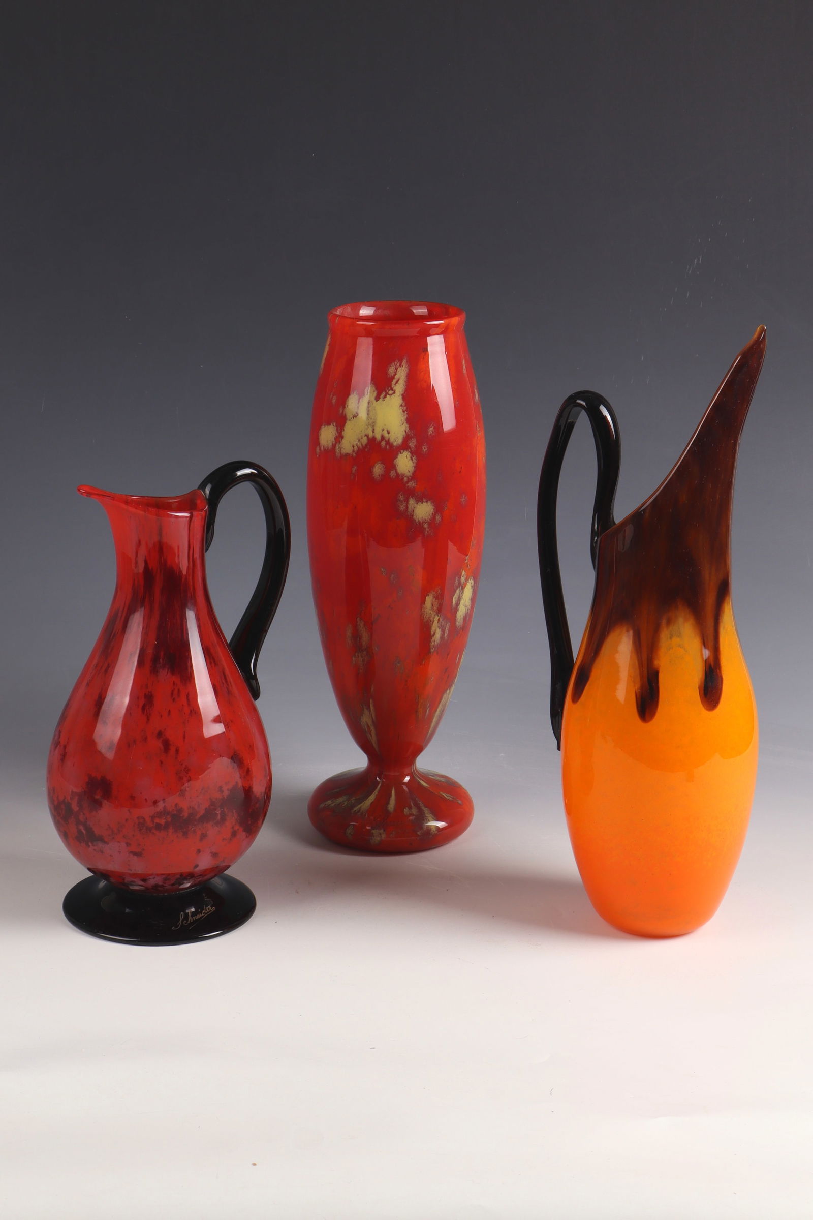 Vase and 2 jugs with handles: Vase and 2 jugs Charles Schneider, Épinay - sur - Seine, 1922 - 1924 Colourless glass with multicoloured flaky powder melting. All parts inscribed: Schneider (engraved) H. 31.5 cm, 33 cm or 25 cm