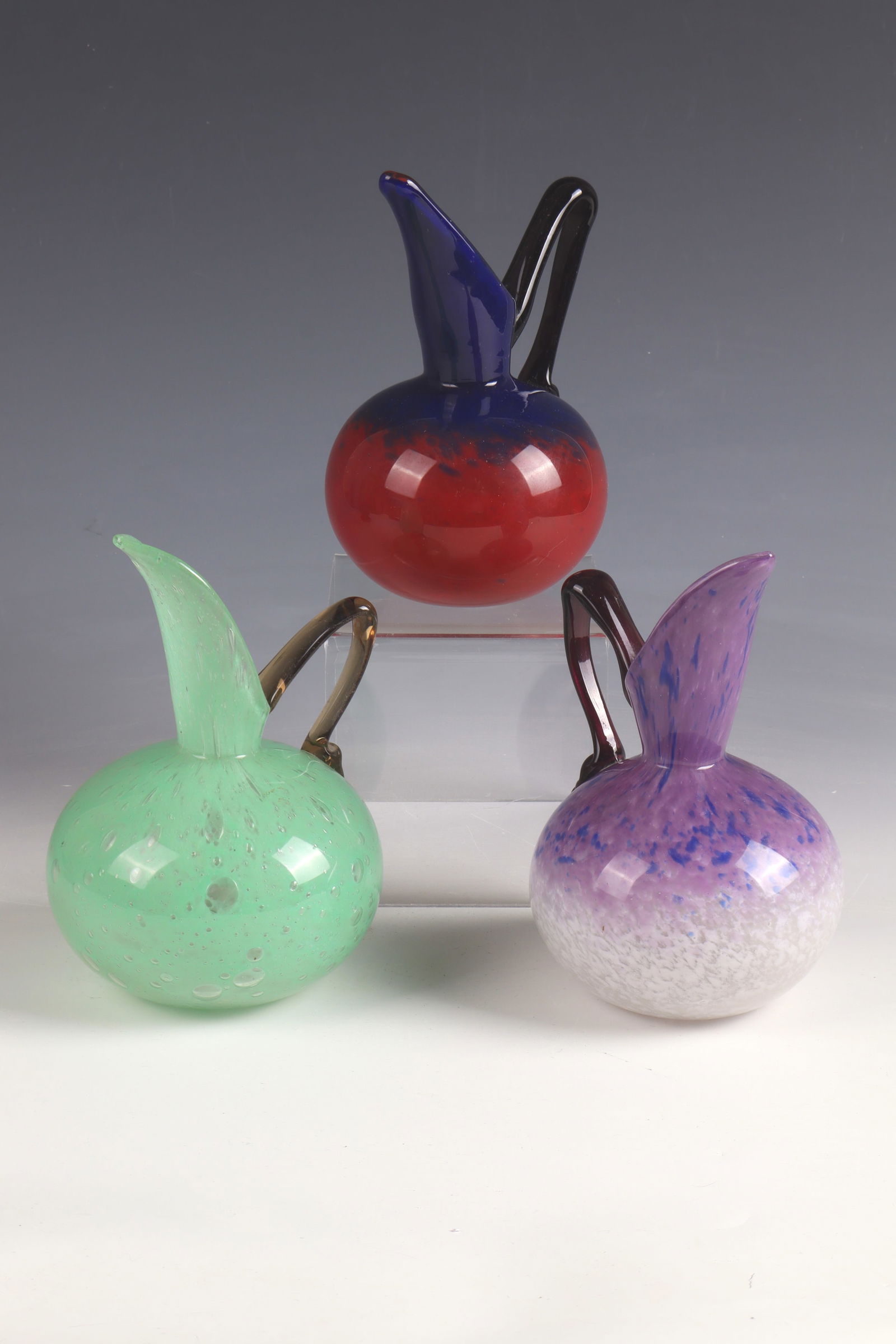 3 jugs of ''Pichets'': 3 Jugs ''Pichets'' Charles Schneider, Épinay - sur - Seine, 1920 - 1926 Colourless glass with flaky multi-coloured powder melting. The partly pinched handle appliqués in colourless with black-violet