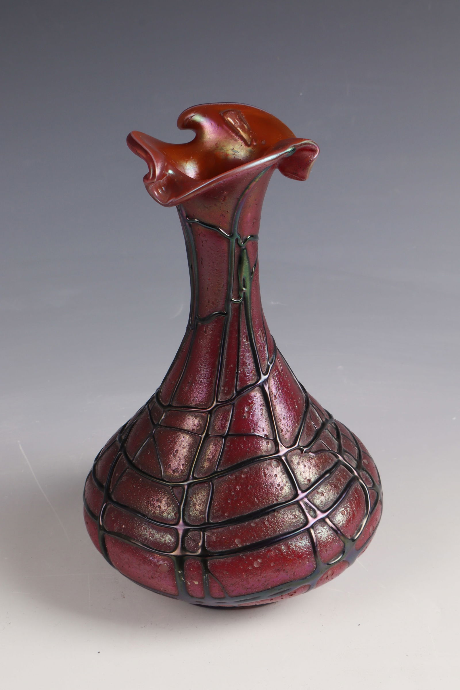 Vase: Vase Glasfabrik Elisabeth, Wilhelm Habel, costs near Teplitz, c. 1900 Colourless glass with dark red overlay. Braided irregularly with violet threads. Iridescent. H. 22 cm Lit.: G. Cappa, Le Genié Ve
