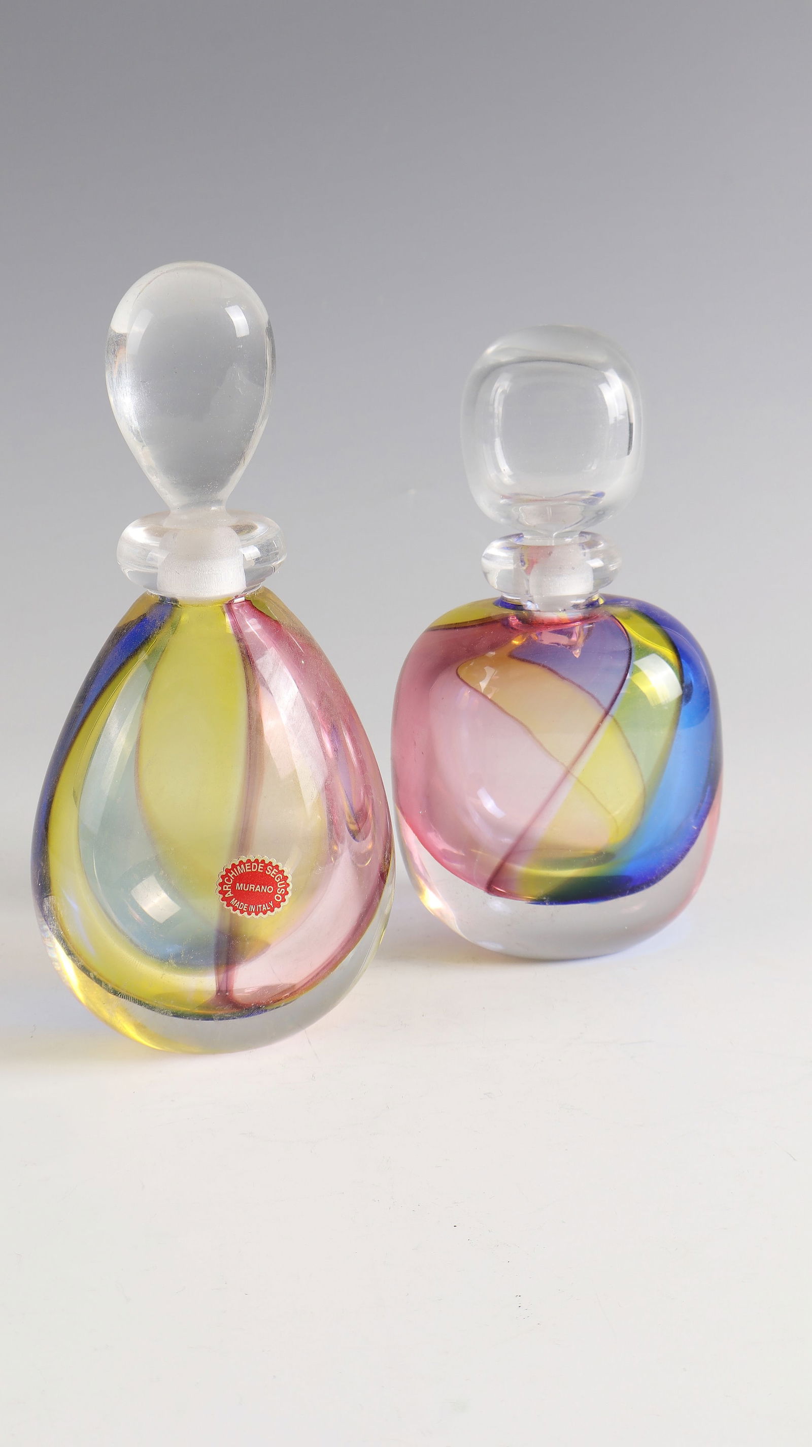 2 bottles with stopper ''carnevale'': 2 flacons with stopper ''carnevale'' Archimede Seguso, Murano, around 1987 Colourless glass with multi-coloured ribbon melting between the layers. Original adhesive label of the manufactory. In vibro
