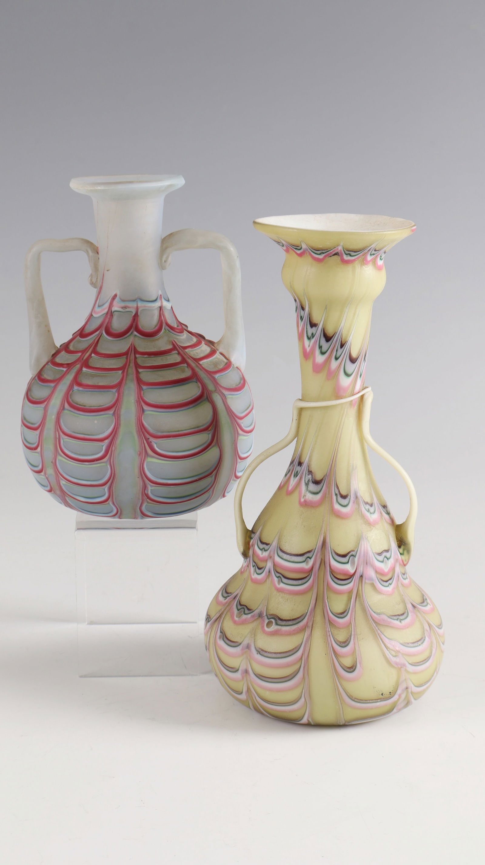 2 Handle Vases ''Fenicio'': 2 handle vases ''Fenicio'' Fratelli Toso, Murano, c. 1900 opal glass with spun, wavy combed coloured threads. Surface matte. H. 20 and 14, 5 cm Lit.: G. Cappa, Le Genié Verrier de l'Europe, ed.: